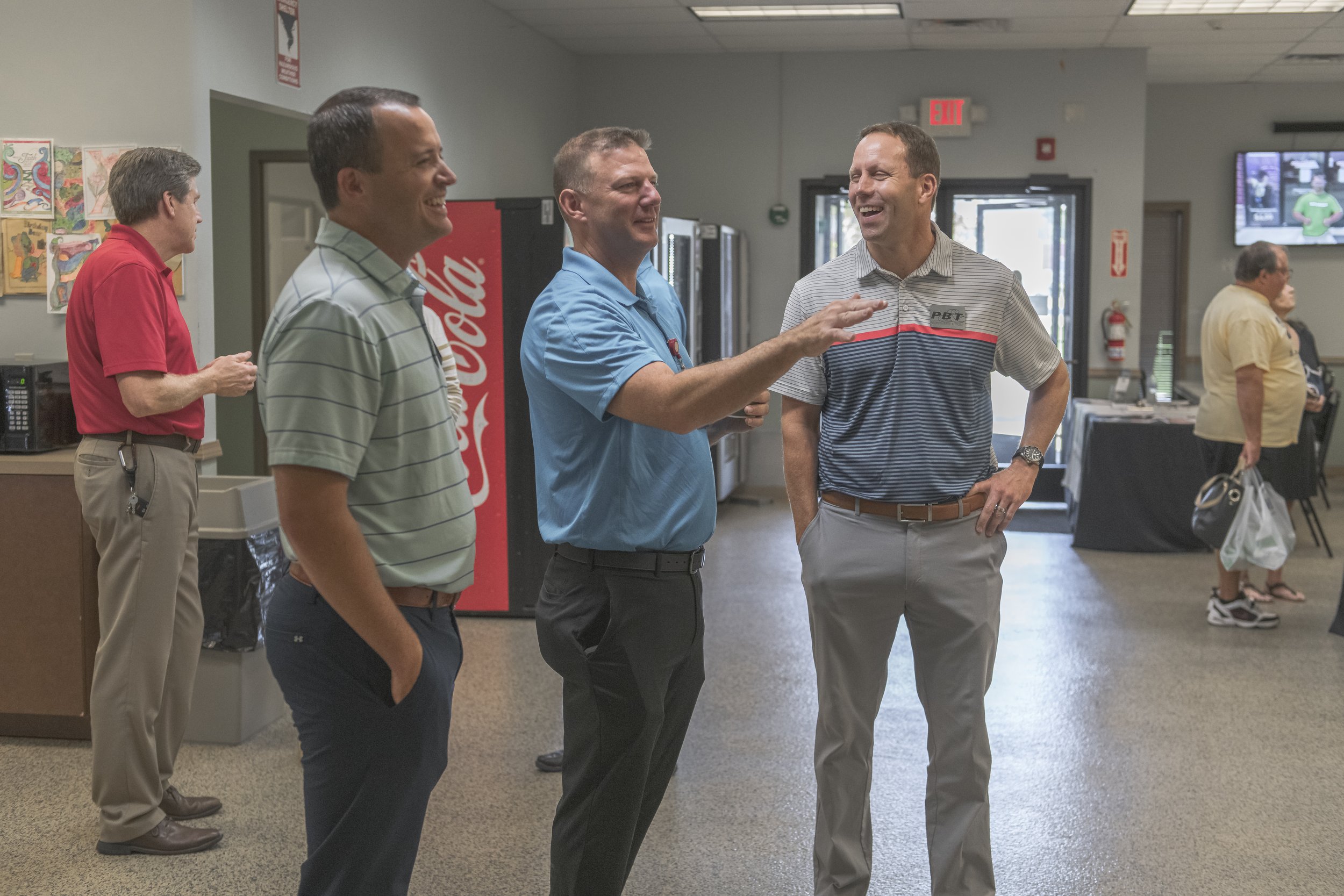 A guide gestures while talking with visitors in the reception area at the 2022 BCI Open House.