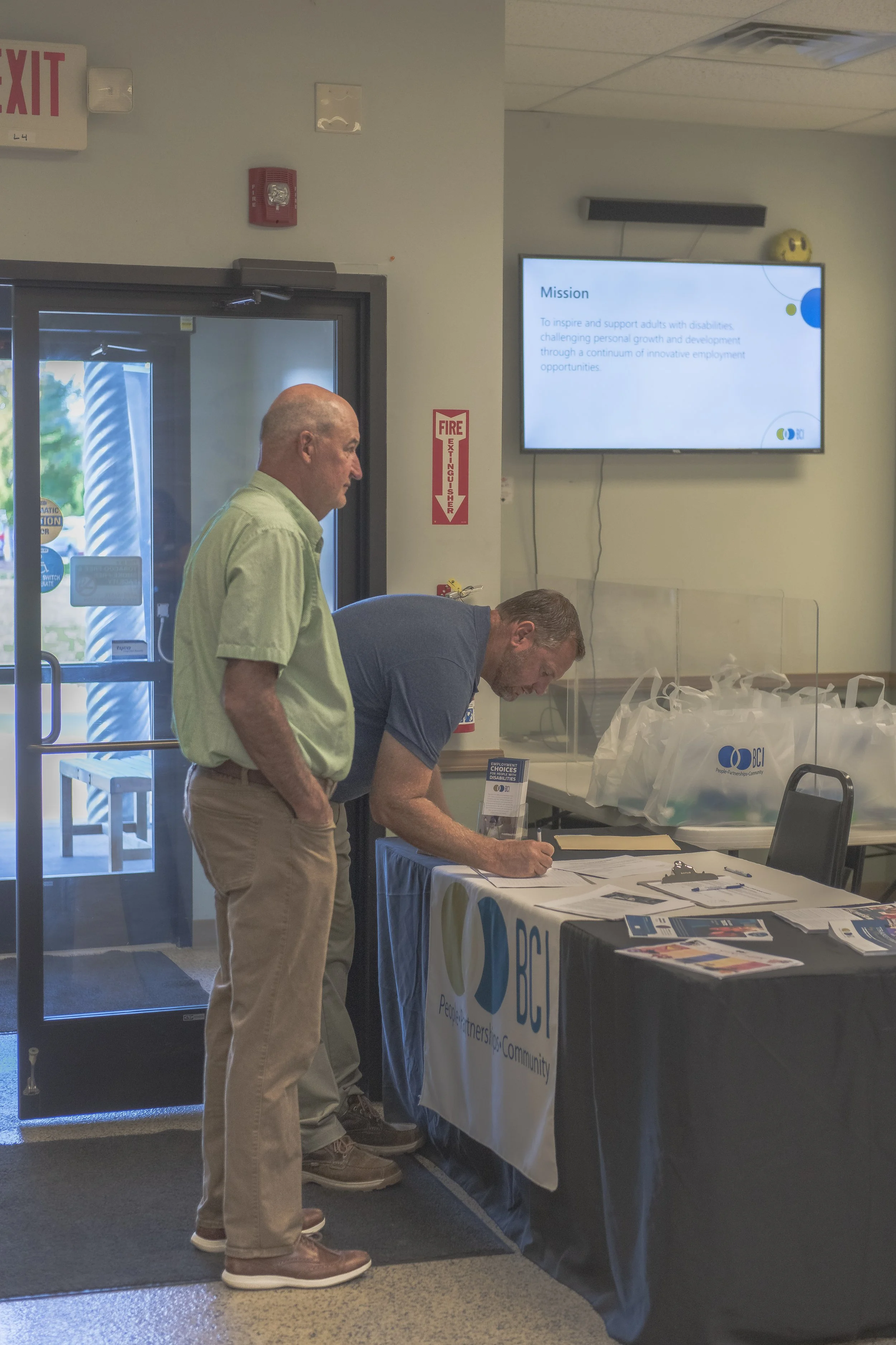 An attendee writes at an information table near the entrance at the 2022 BCI Open House.