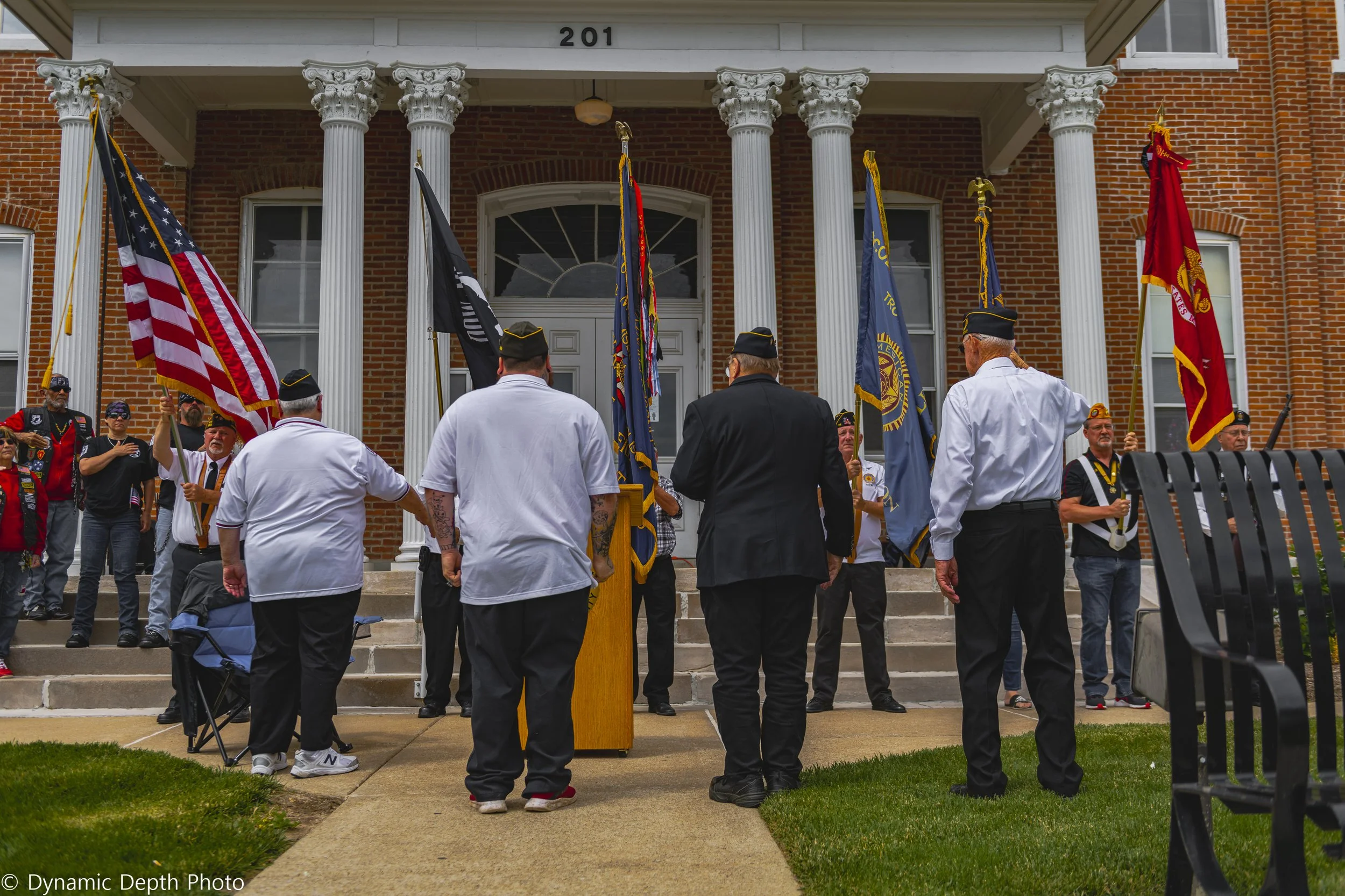 Ceremony participants stand facing the flag bearers near the entrance during the 2021 Memorial Day Service.