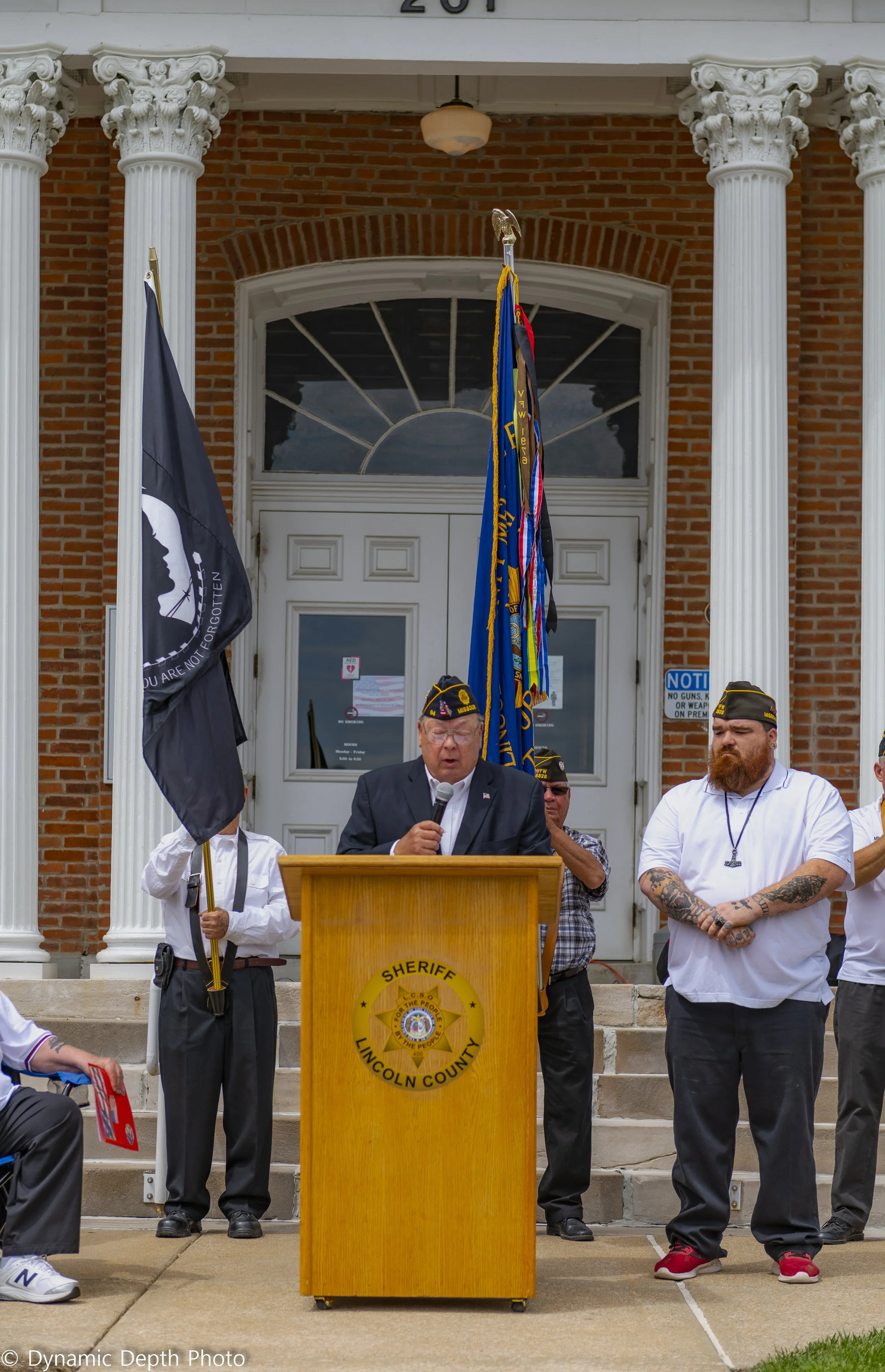 A speaker addresses attendees from a wooden lectern during the 2021 Memorial Day Service.