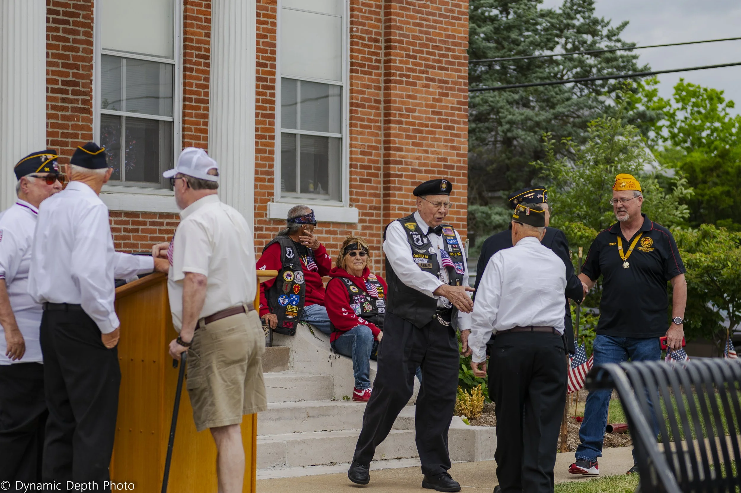 Ceremony participants greet one another beside the building steps at the 2021 Memorial Day Service.