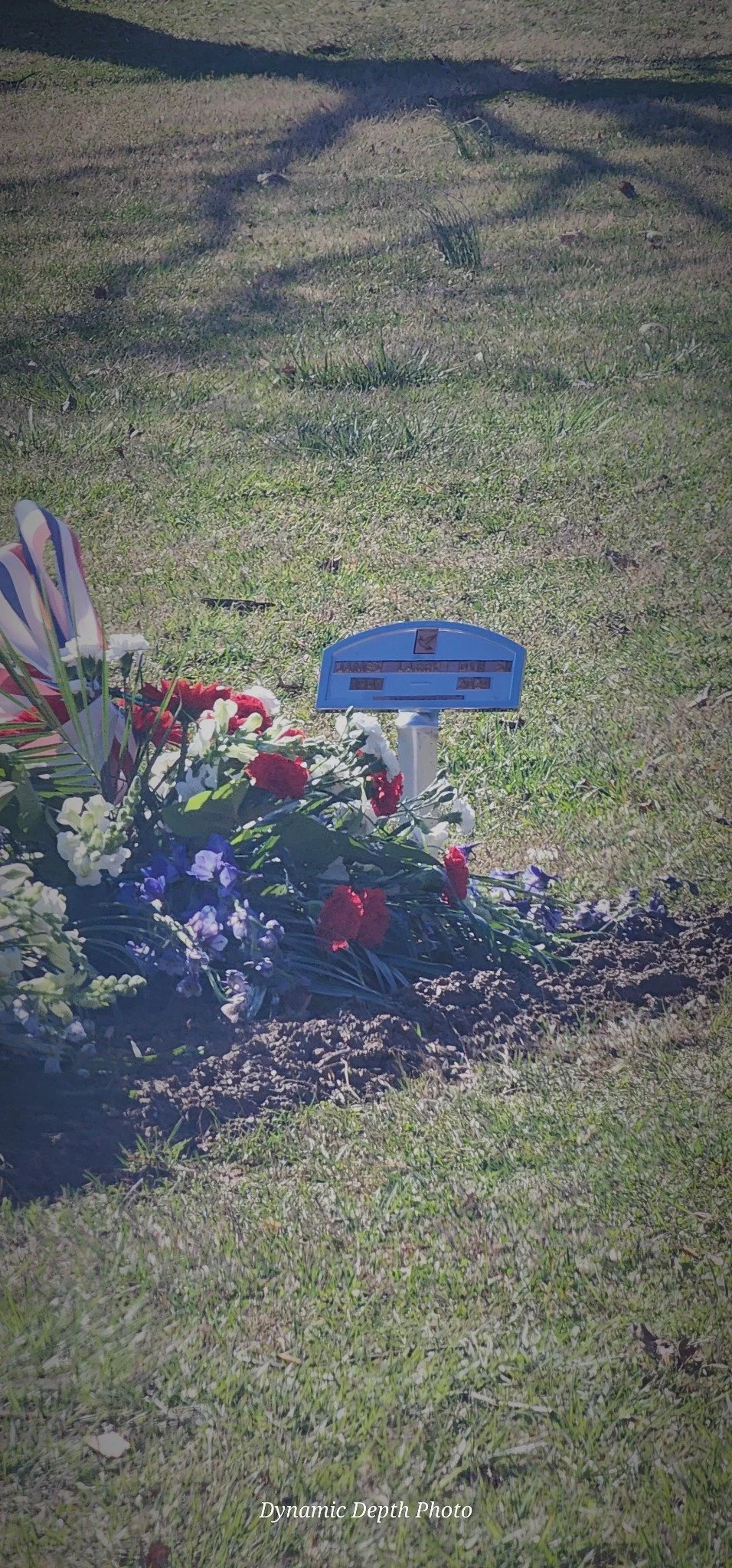 Flowers beside James Larry Dye, Sr.'s grave marker