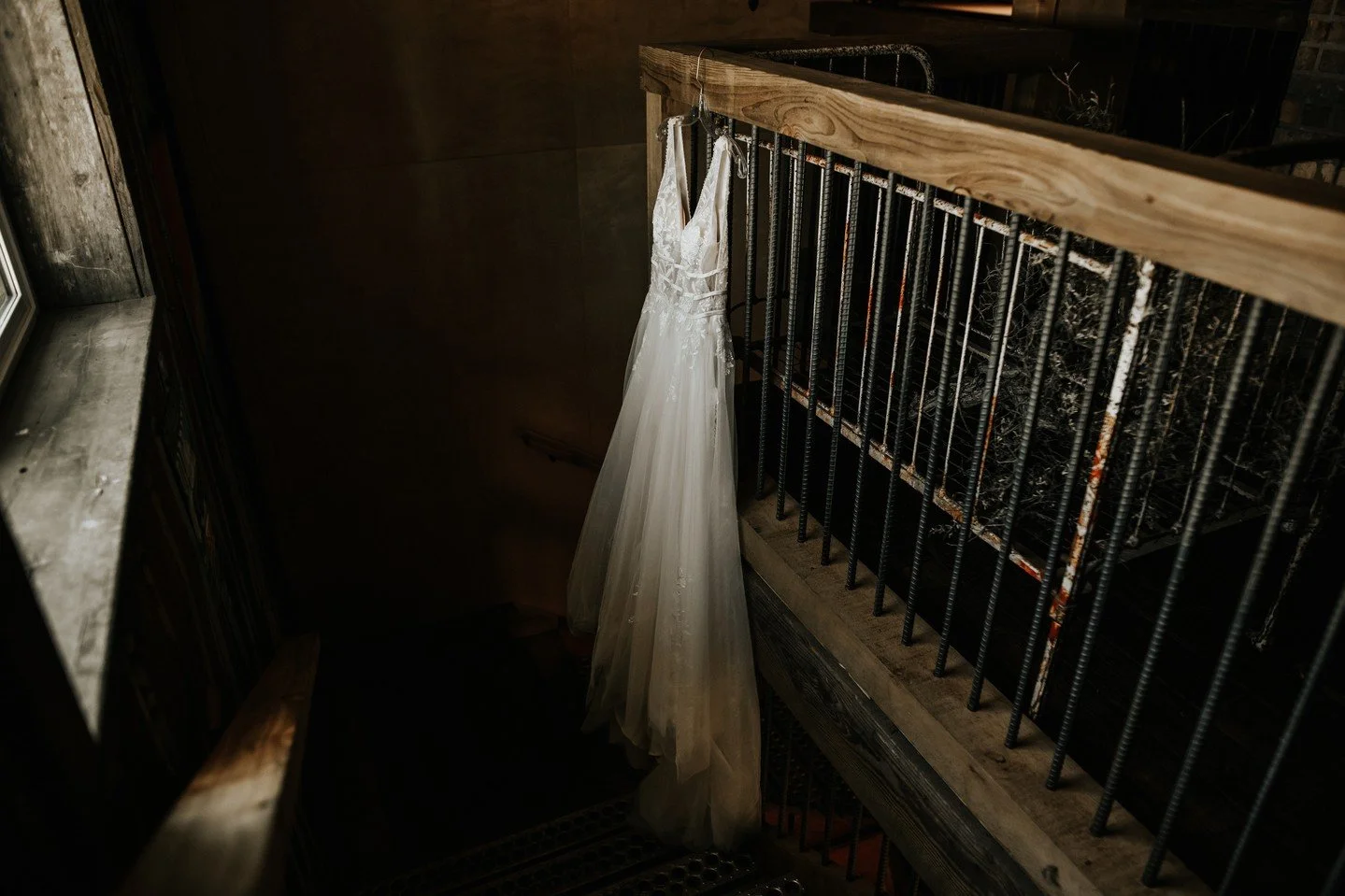 Your wedding dress is more than fabric and lace, it's a symbol of anticipation. When displaying your gown on the morning-of, consider where it will be captured. 
Natural textures like wood, iron, or stone add depth and contract, while soft light r