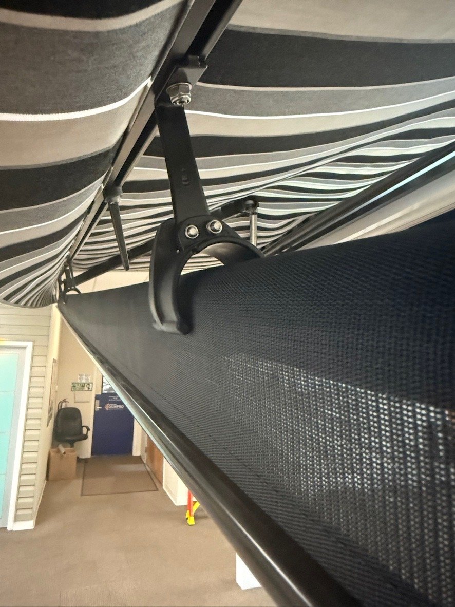 Centr support bracket for drop shade that works with awnings.