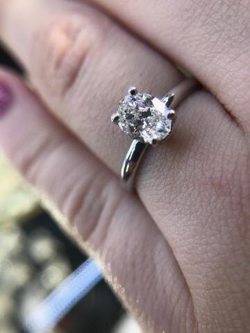 This custom solitaire engagement ring features an F VS1 oval Certified Canadian diamond. Its classic dainty design was designed by Secrète for a Northern Virginia couple in 2018.