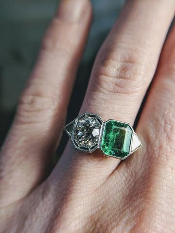 This vintage two stone engagement ring from Secrète's DuPont Circle estate cabinet features a 1.01 ct F color VS1 Old Mine cut diamond next to a beautiful grass-green emerald. Two stones symbolize "you and me."