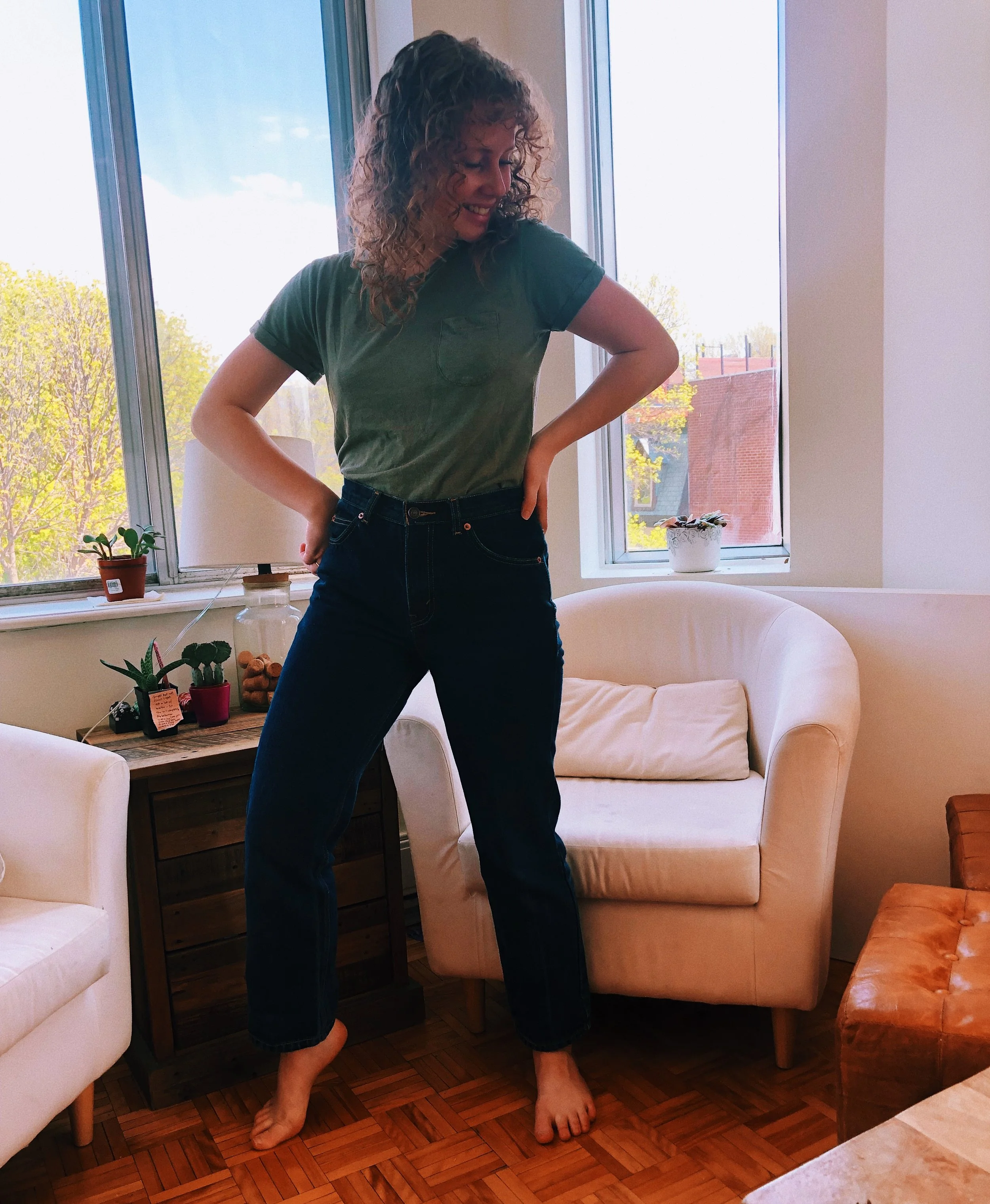 Girl models green t-shirt tucked into high-waisted jeans