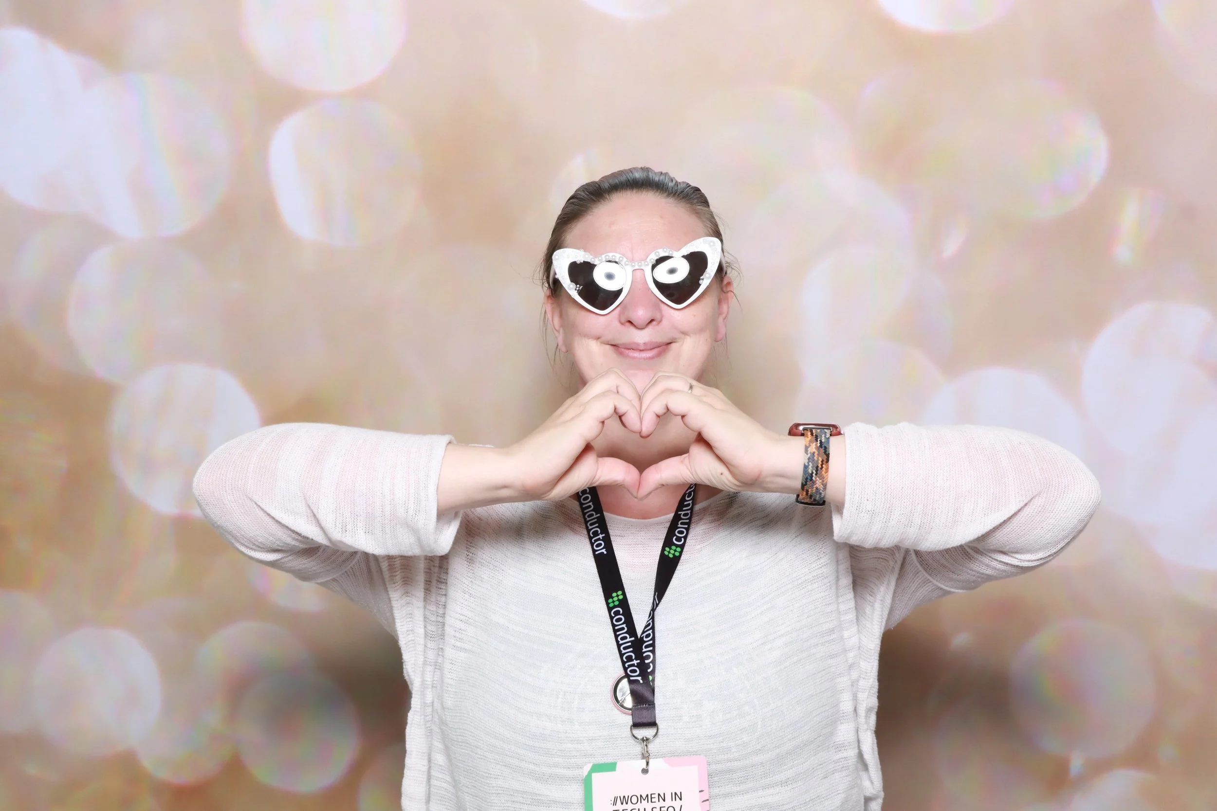 Kate Hagan Gallup with heart shaped hands and women in tech lanyard