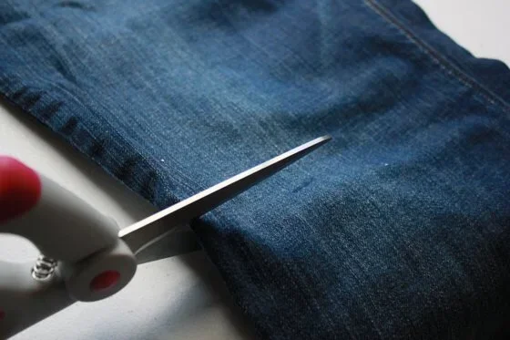 scissors cutting into denim