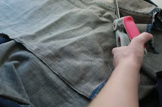 cutting excess fabric while making a denim skirt