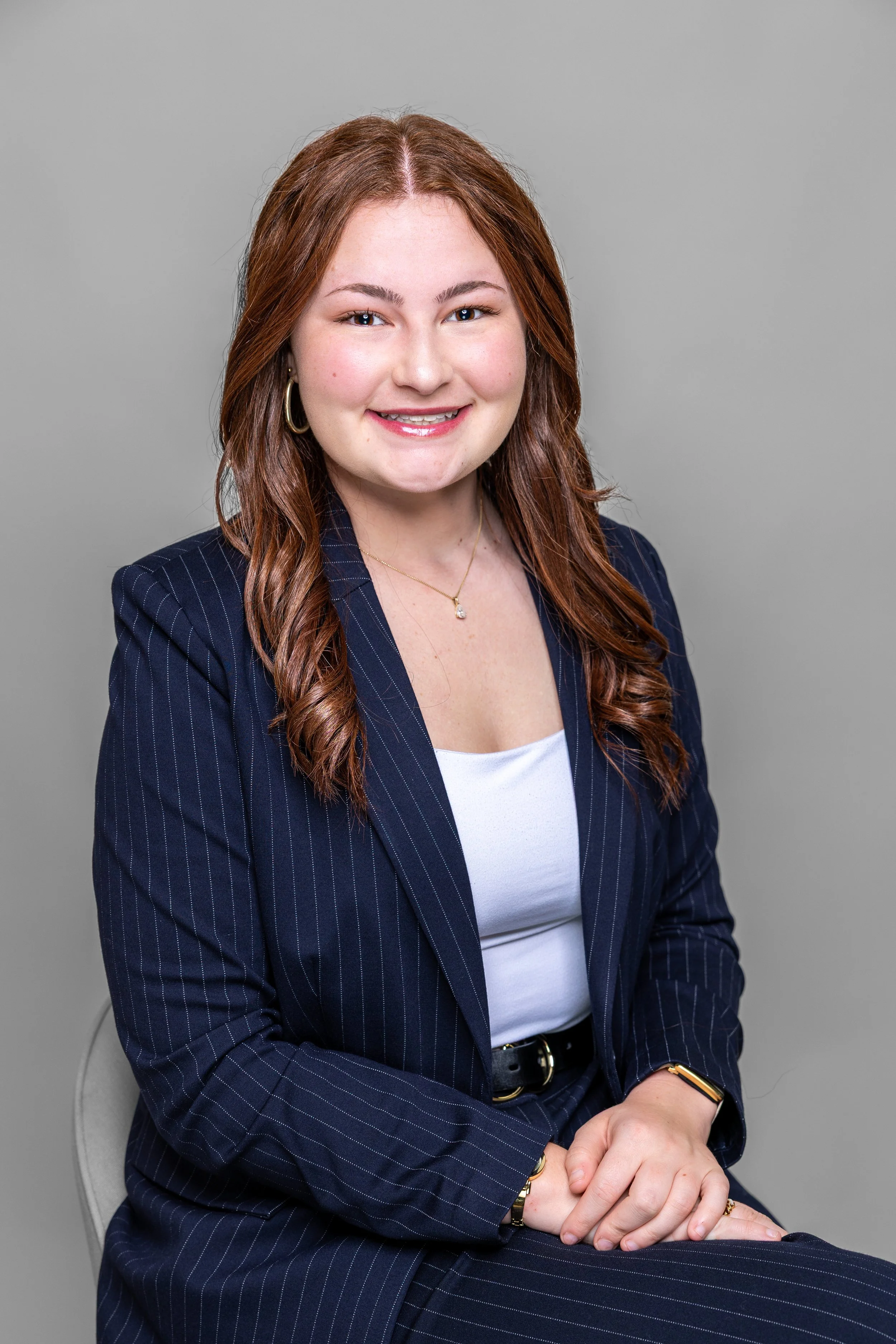 A young lady sits for a professional headshot to update her resume
