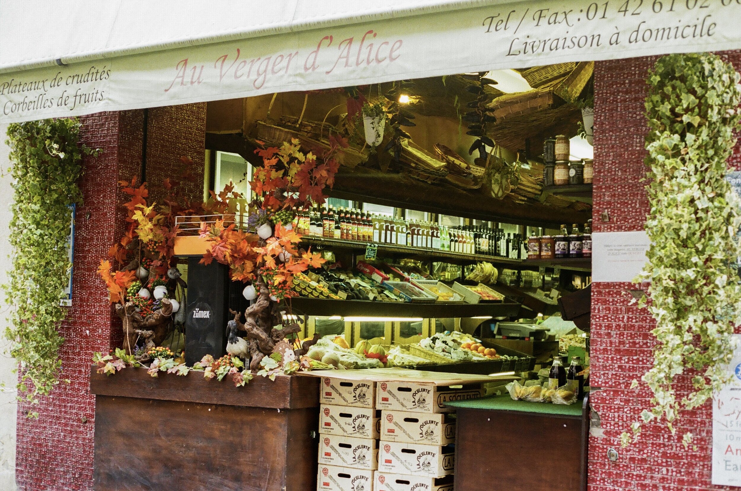   A small market blocks its entrance with clementine boxes, which are used as a makeshift order counter.  