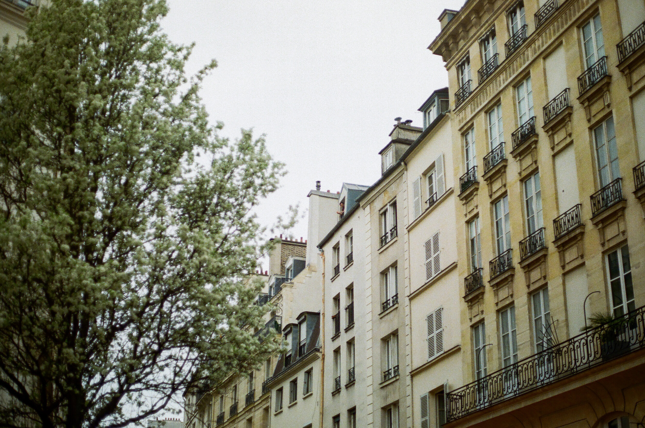   A man looks out his window at the empty streets below.  