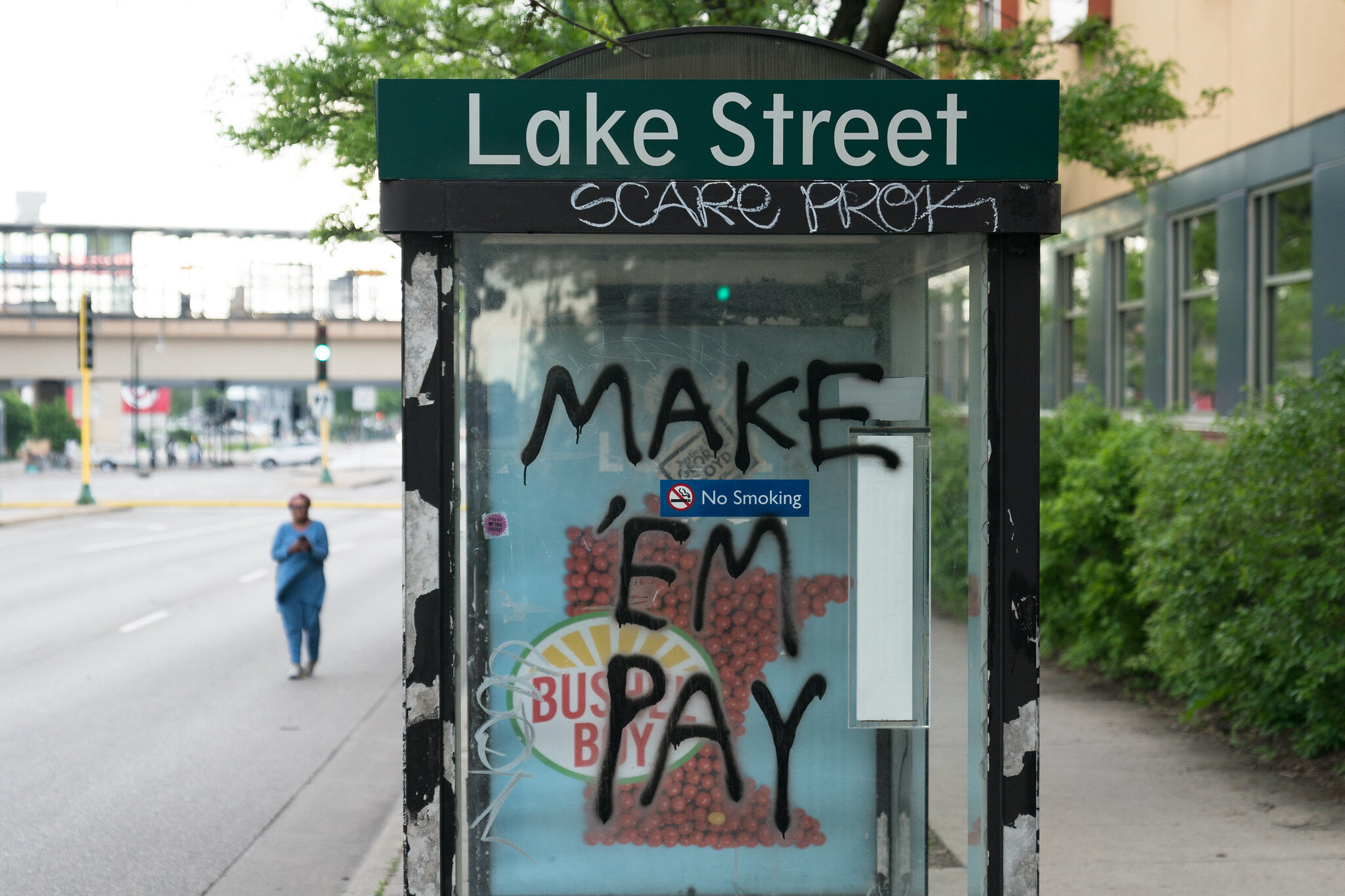  Make 'Em Pay graffiti at a bus stop on Lake Street on Thursday morning after a night of protests in Minneapolis, Minnesota 