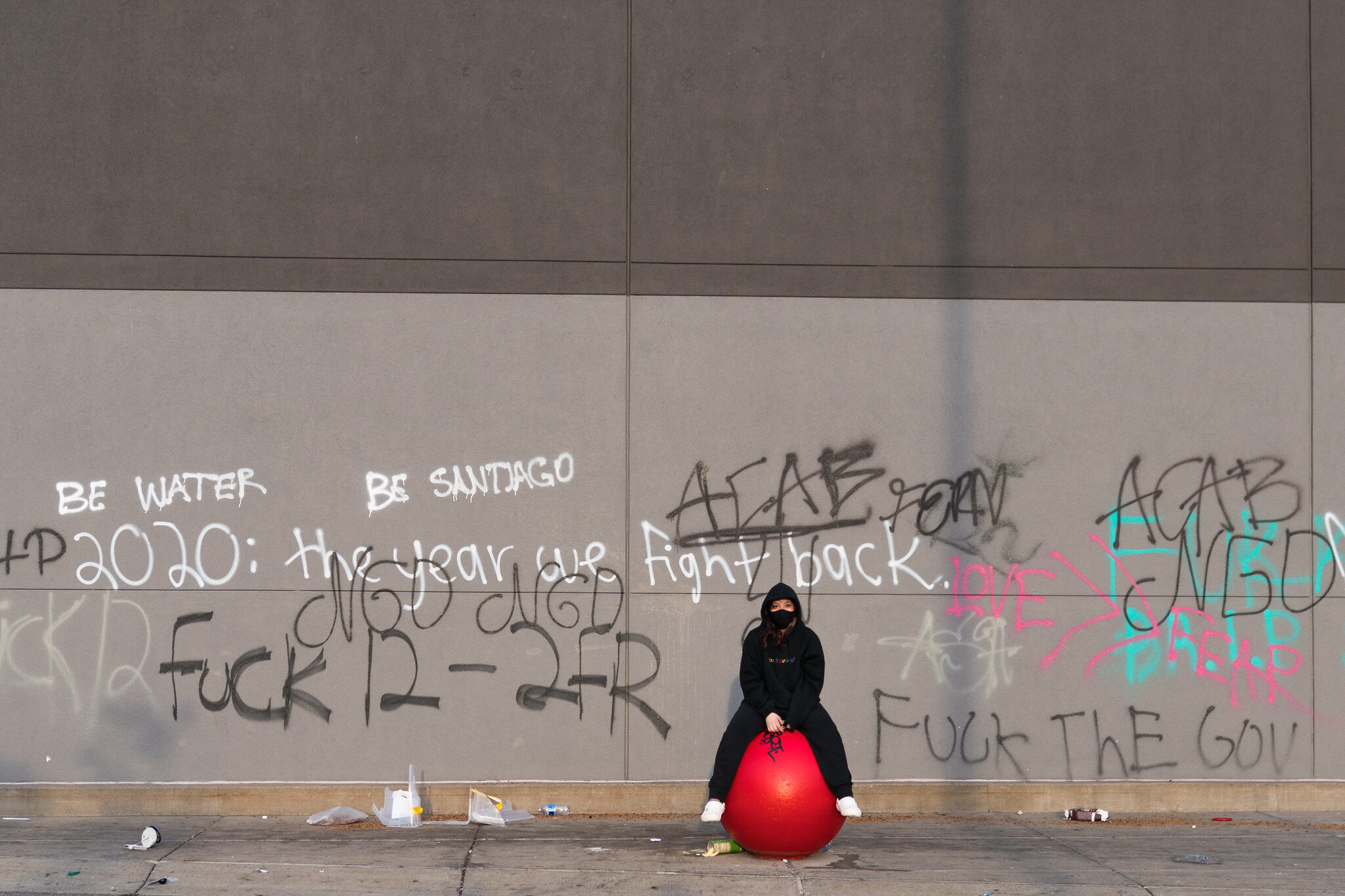  A woman sits on a Target ball in front of the store on Thursday morning. The store was looted and graffitied after a night of protests in Minneapolis, Minnesota 