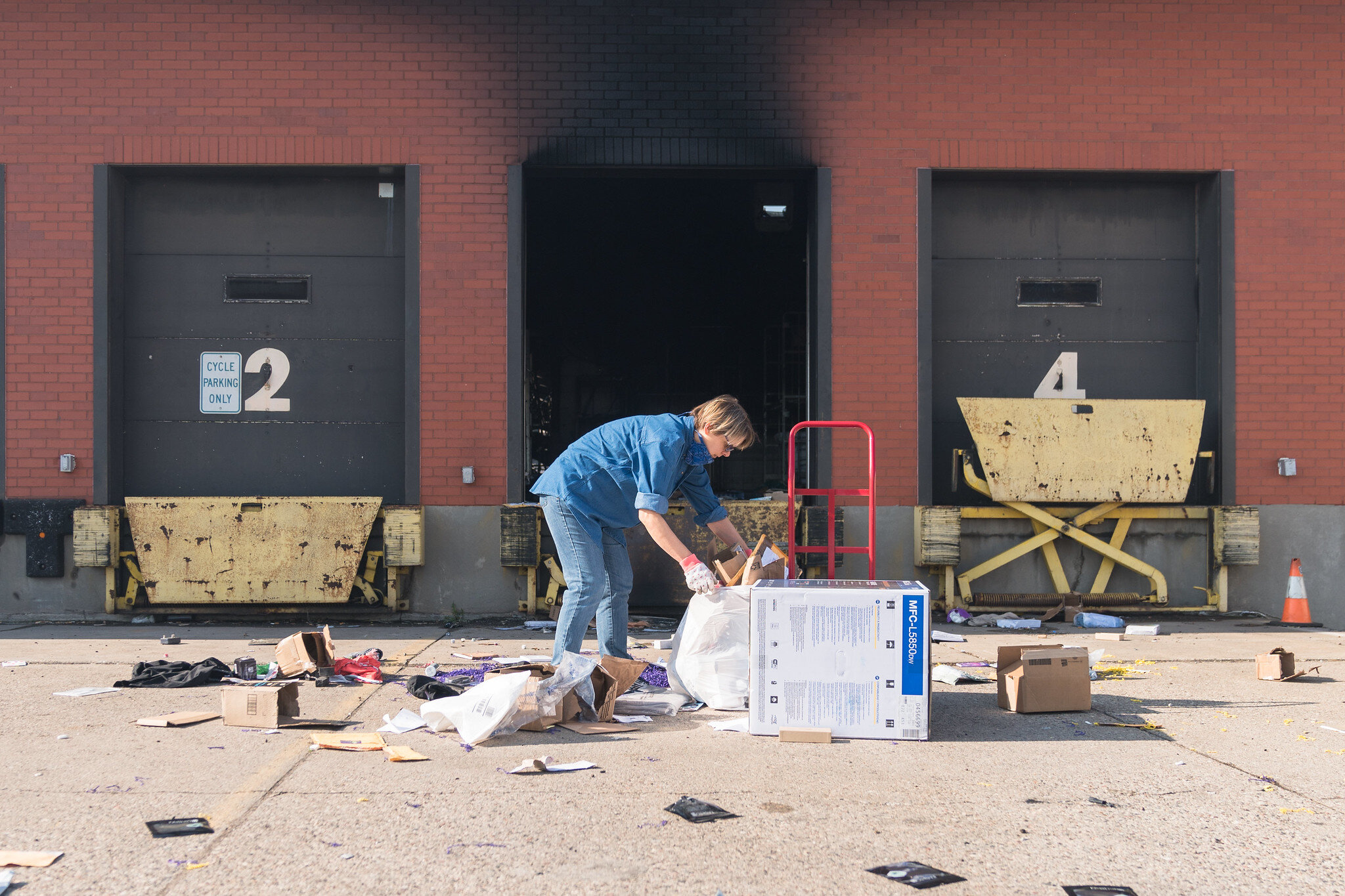  A woman cleans up trash and mail on Saturday morning behind the Post Office destroyed by rioters on Friday night in Minneapolis, Minnesota 
