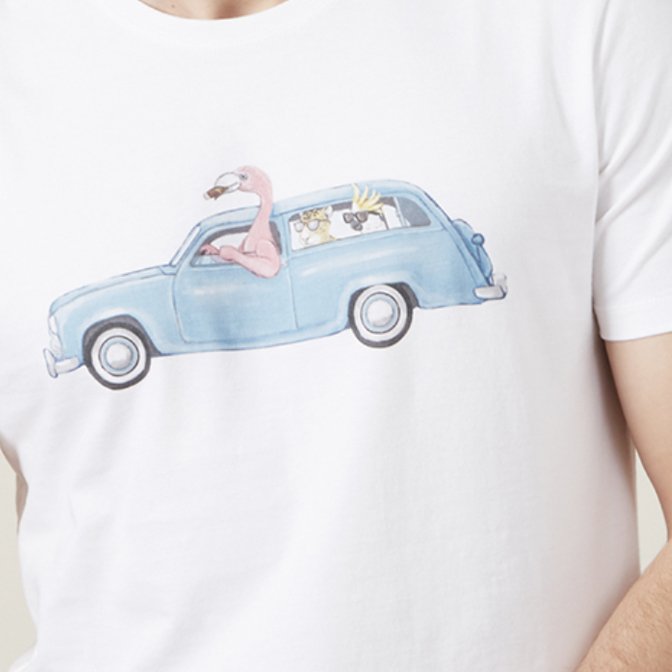 A white T-shirt with a printed illustration of a blue vintage car and cartoon characters, including a pink flamingo and two other animals, inside the car.