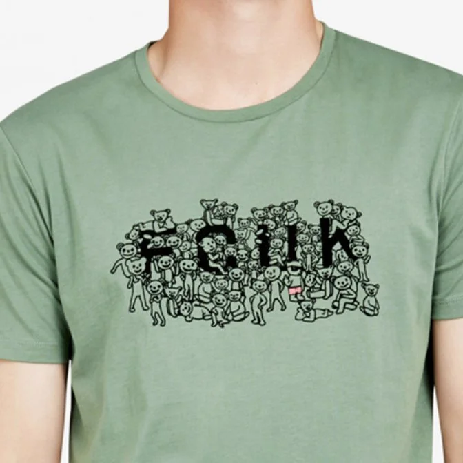 Green t-shirt with the phrase FCUK written in large black letters, surrounded by small cartoon characters.