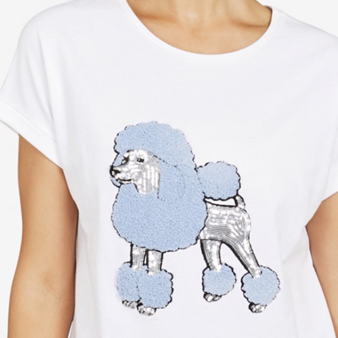 White t-shirt with a sequined and textured poodle design in blue and silver.