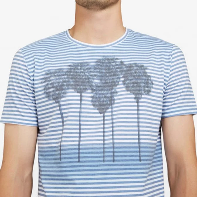 A man wearing a light blue and white horizontally striped T-shirt with a palm trees graphic on the front.
