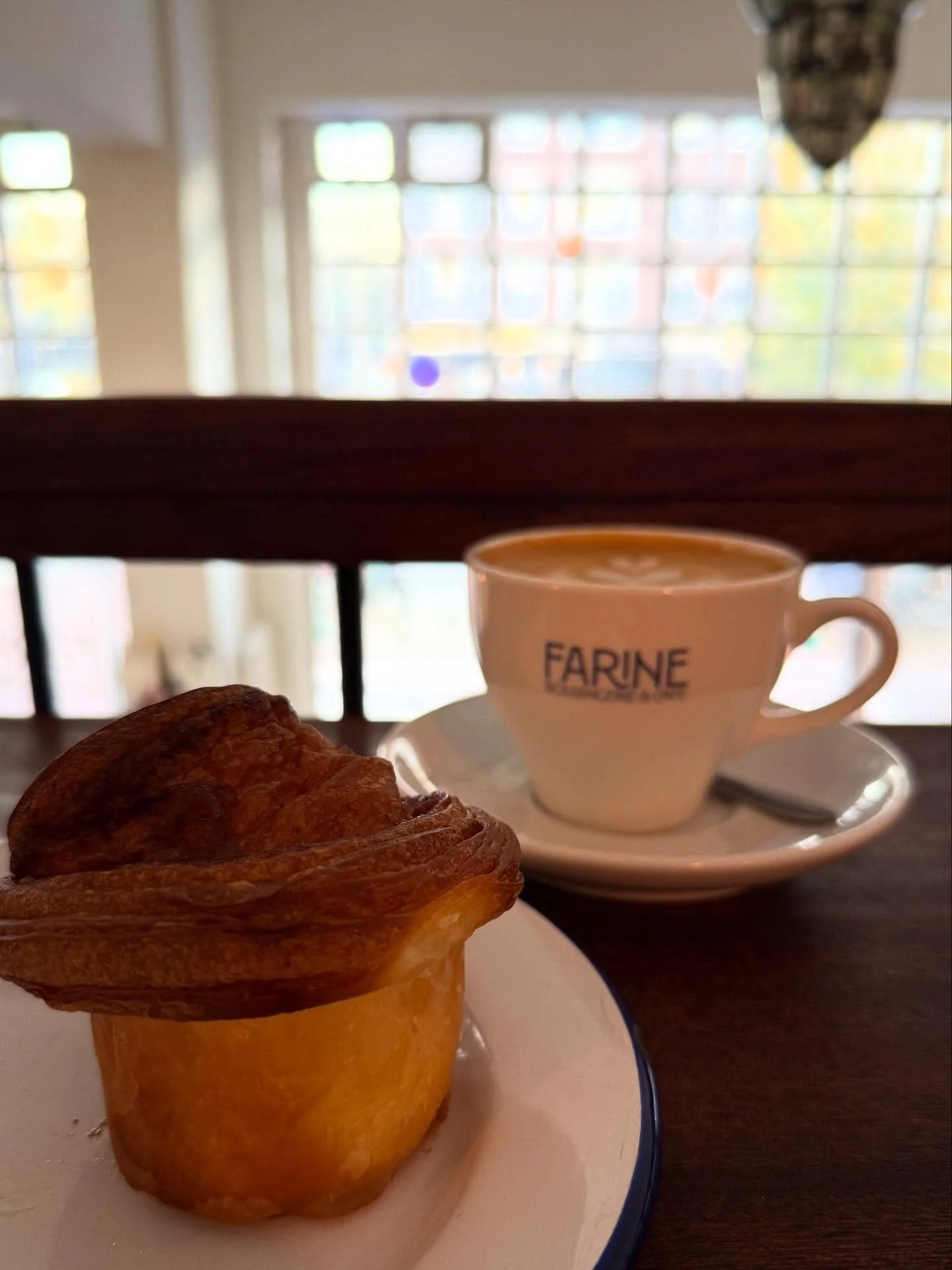 Cinnamon bun cruffin and a flat white at @farine.amsterdam