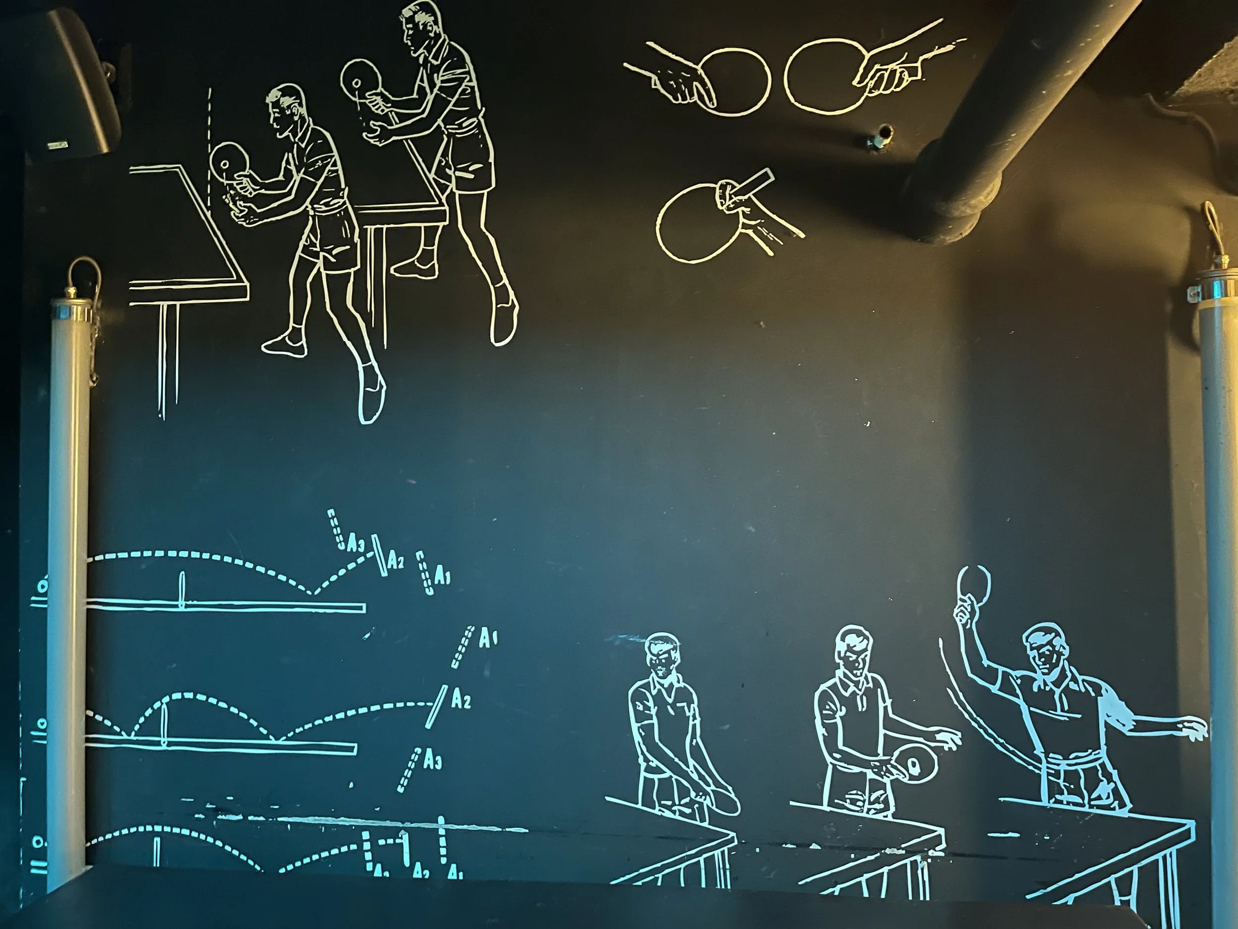 Illustration de techniques de tennis de table sur un mur noir.