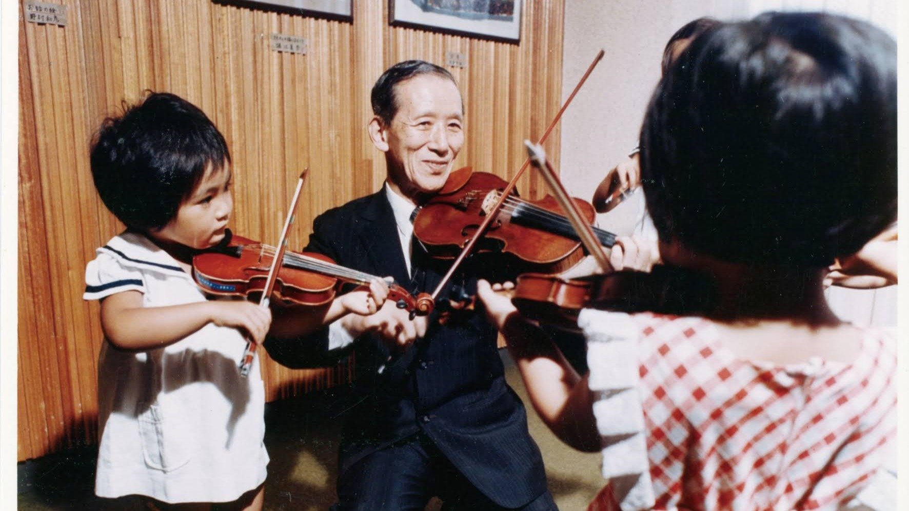A close-up of a child's feet tapping on the floor in time with violin music