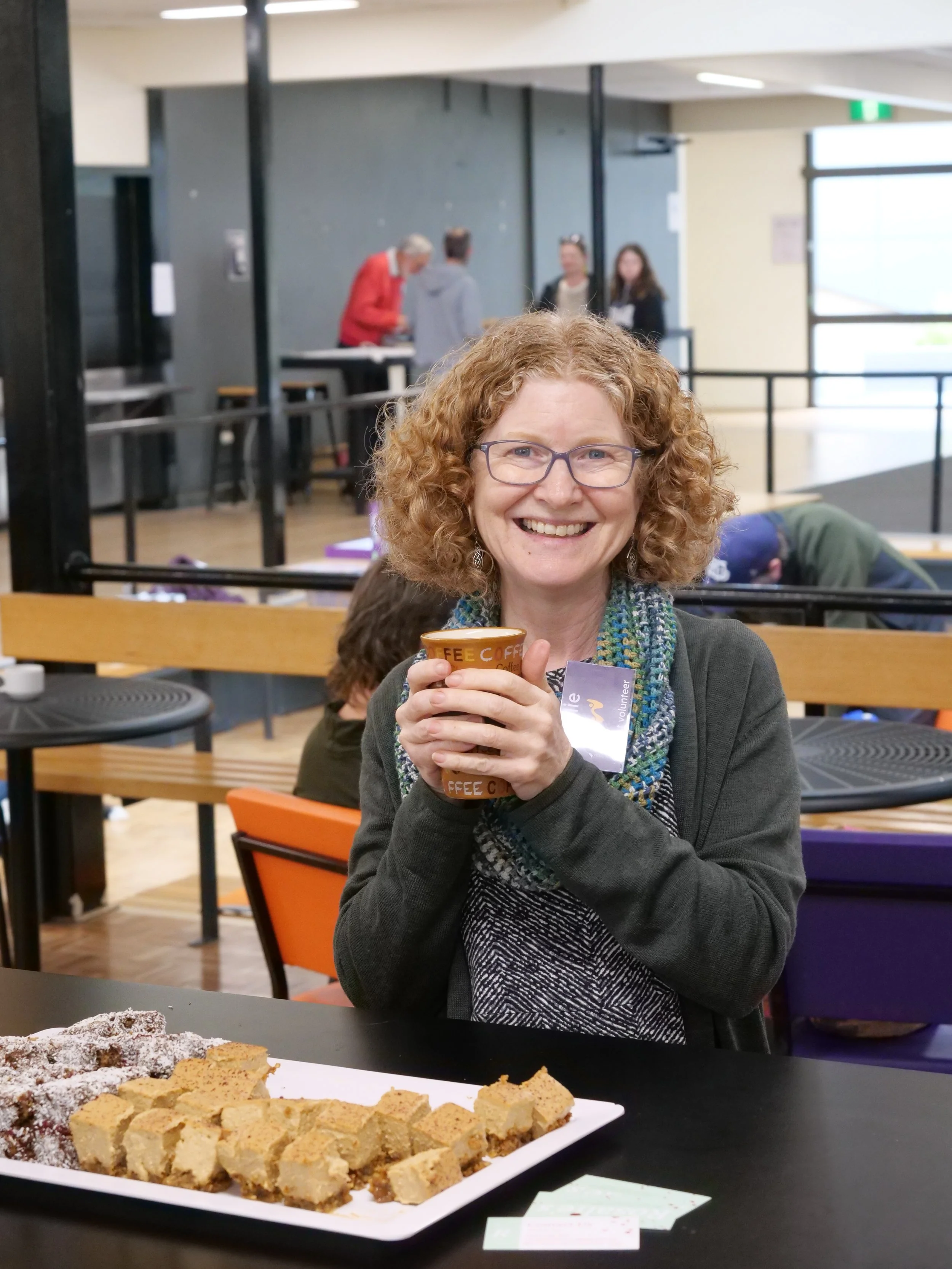 Woman smiling with coffee.