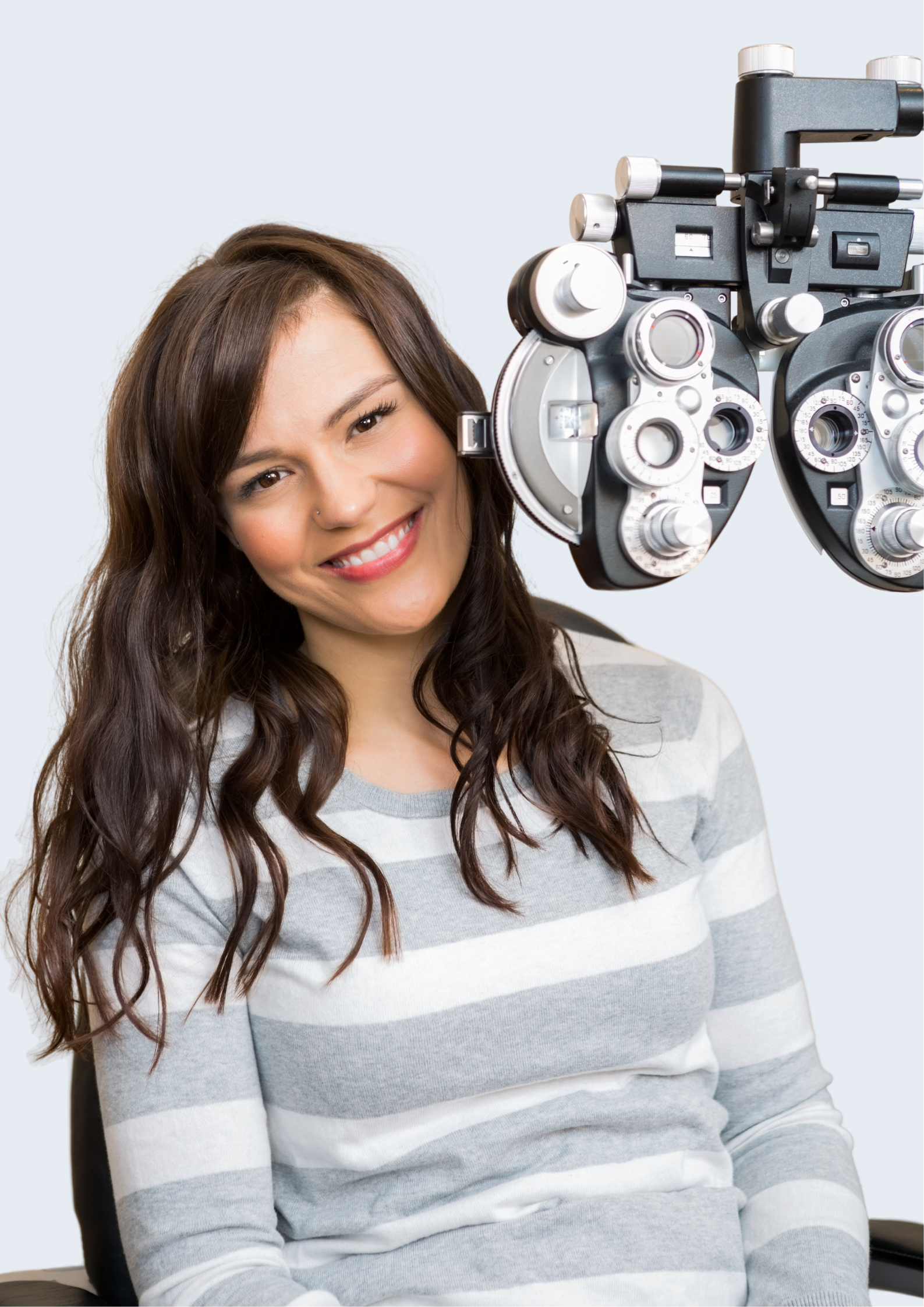 Adult female smiling in the optometry testing room as she has her eyes tested
