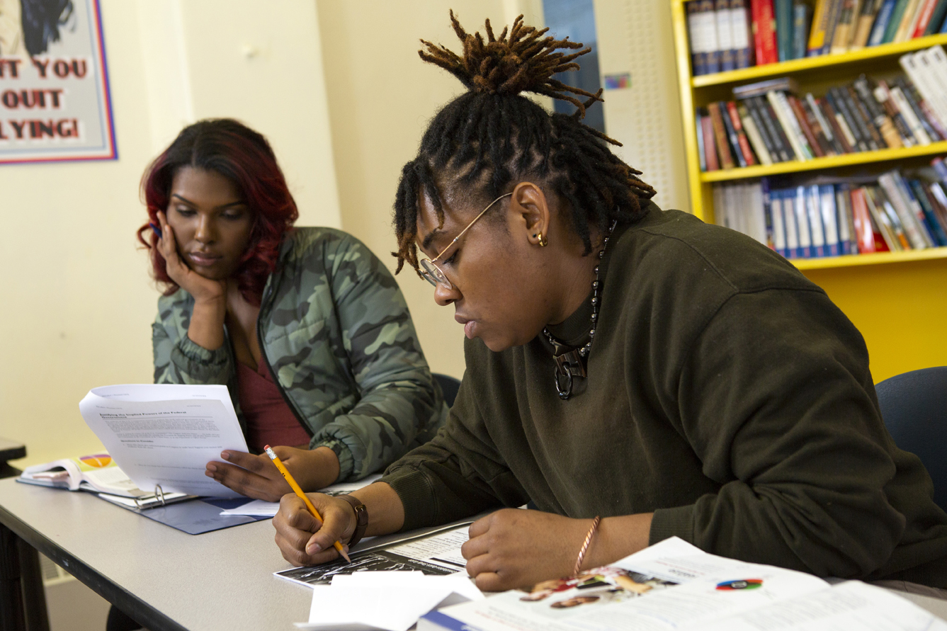 A non-binary student taking notes in class.jpg