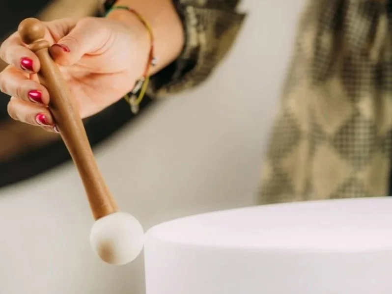 Person using a mallet to hit a white cake or object.