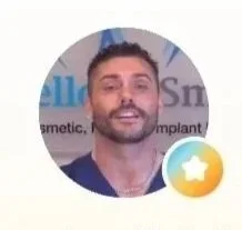 Portrait of a smiling man with facial hair inside a circular frame, with a blurred background and a star badge overlay.