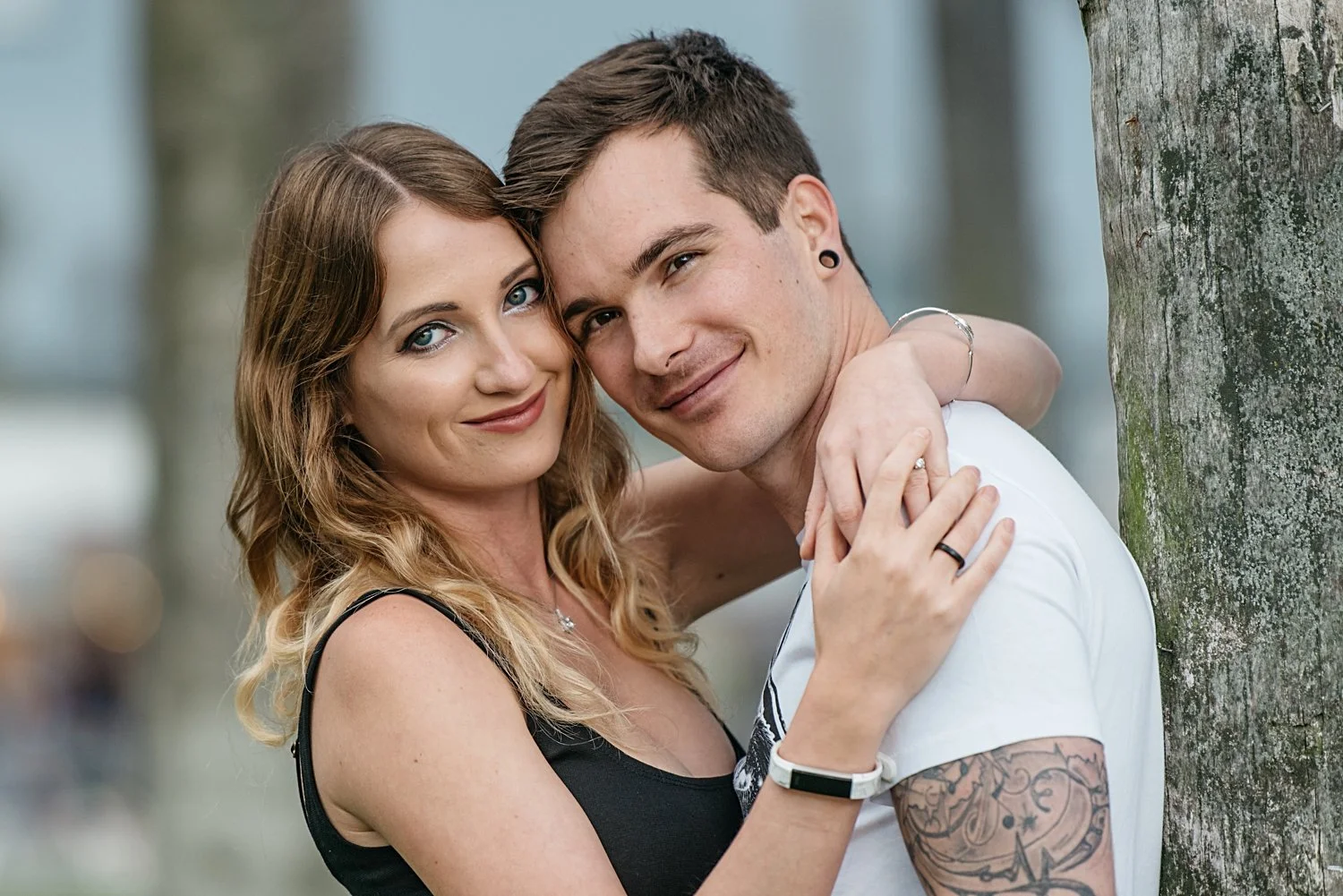 Couple embracing by a tree during engagement session at Venice Beach in Los Angeles by Yana’s Photos