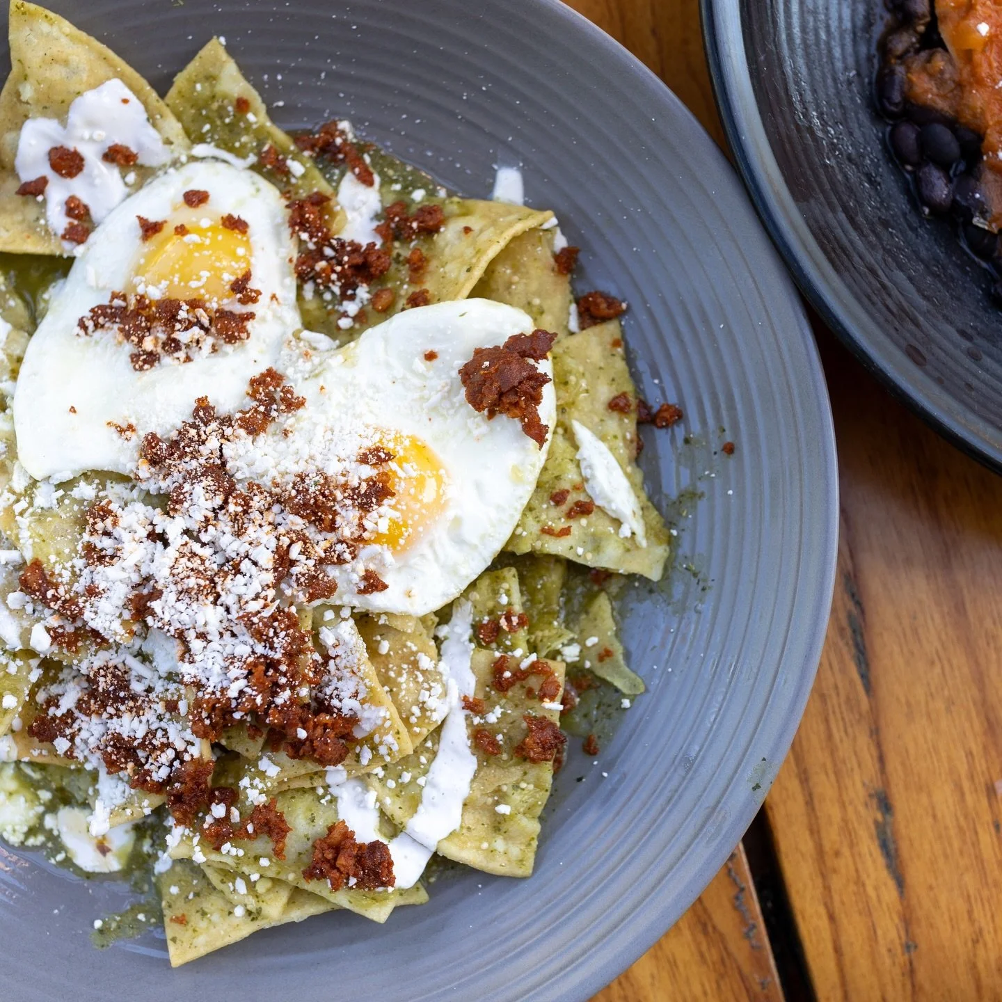 Chilaquiles. Crispy tortillas, warm salsa verde, chorizo, crema
and eggs worth breaking into. 🍳