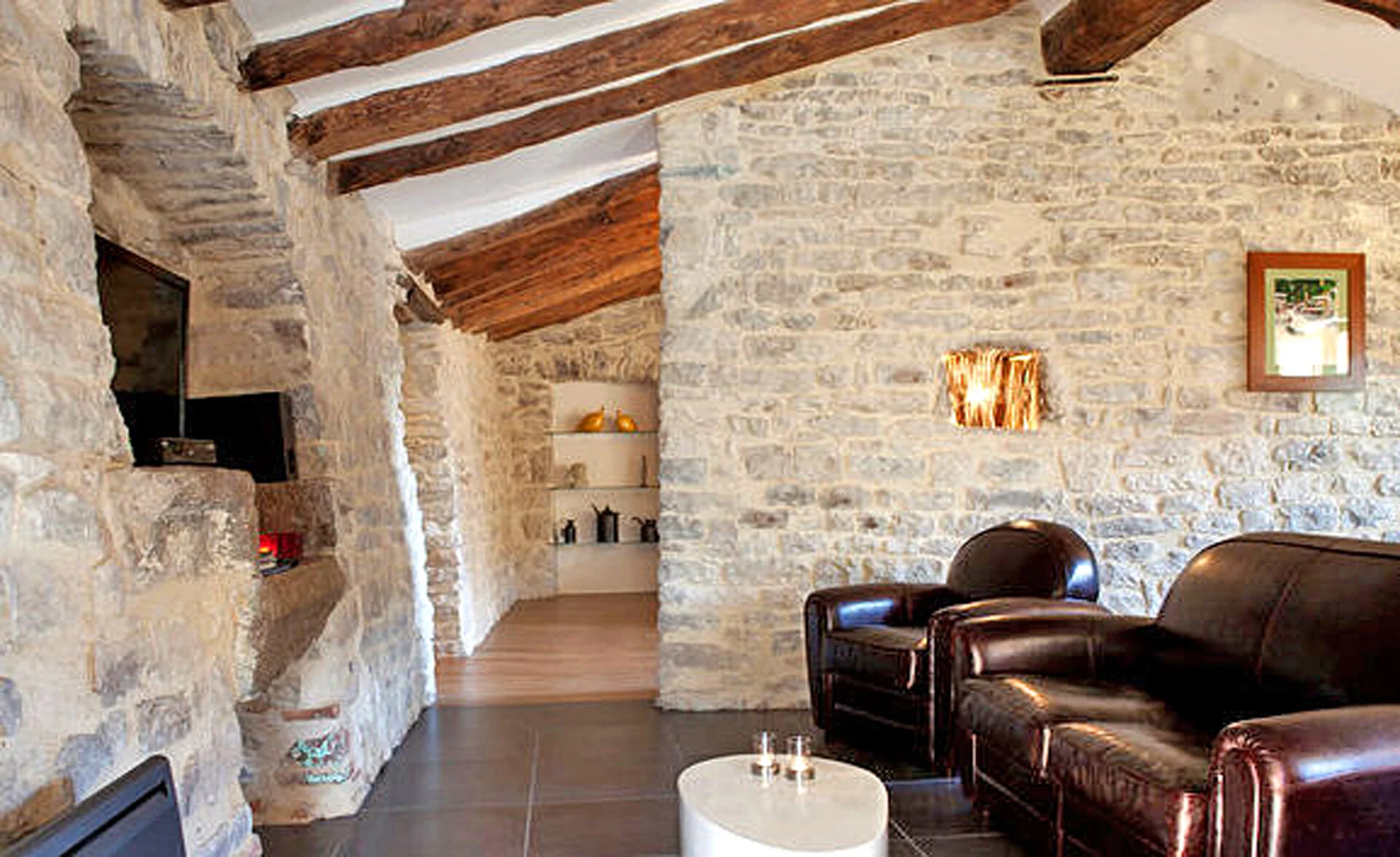 Séjour en pierres apparentes et anciennes poutres pour ce gite de charme dans le Languedoc près de Quissac