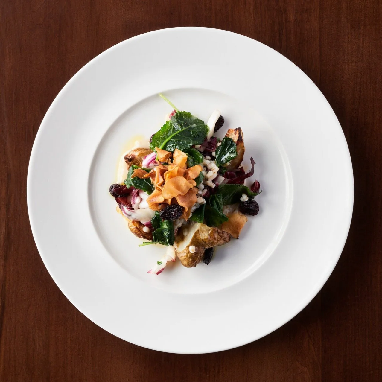 An appetizer of Roasted Sunchoke Toasted Barley, Cranberry, Maple-Tahini Dressing
