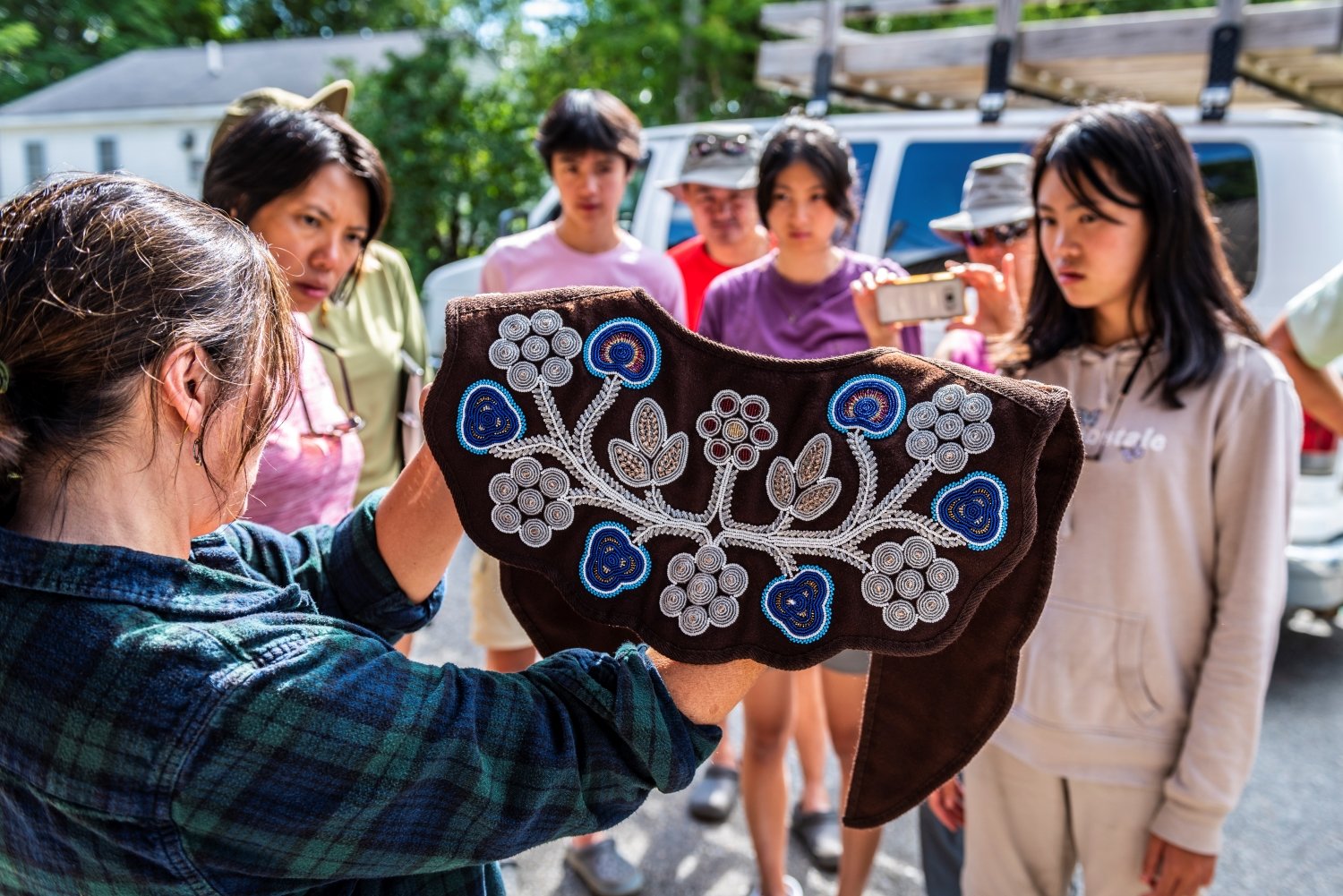 Jennifer Neptune shows guests an embroidered collar outside the Penobscot Museum on Indian Island.