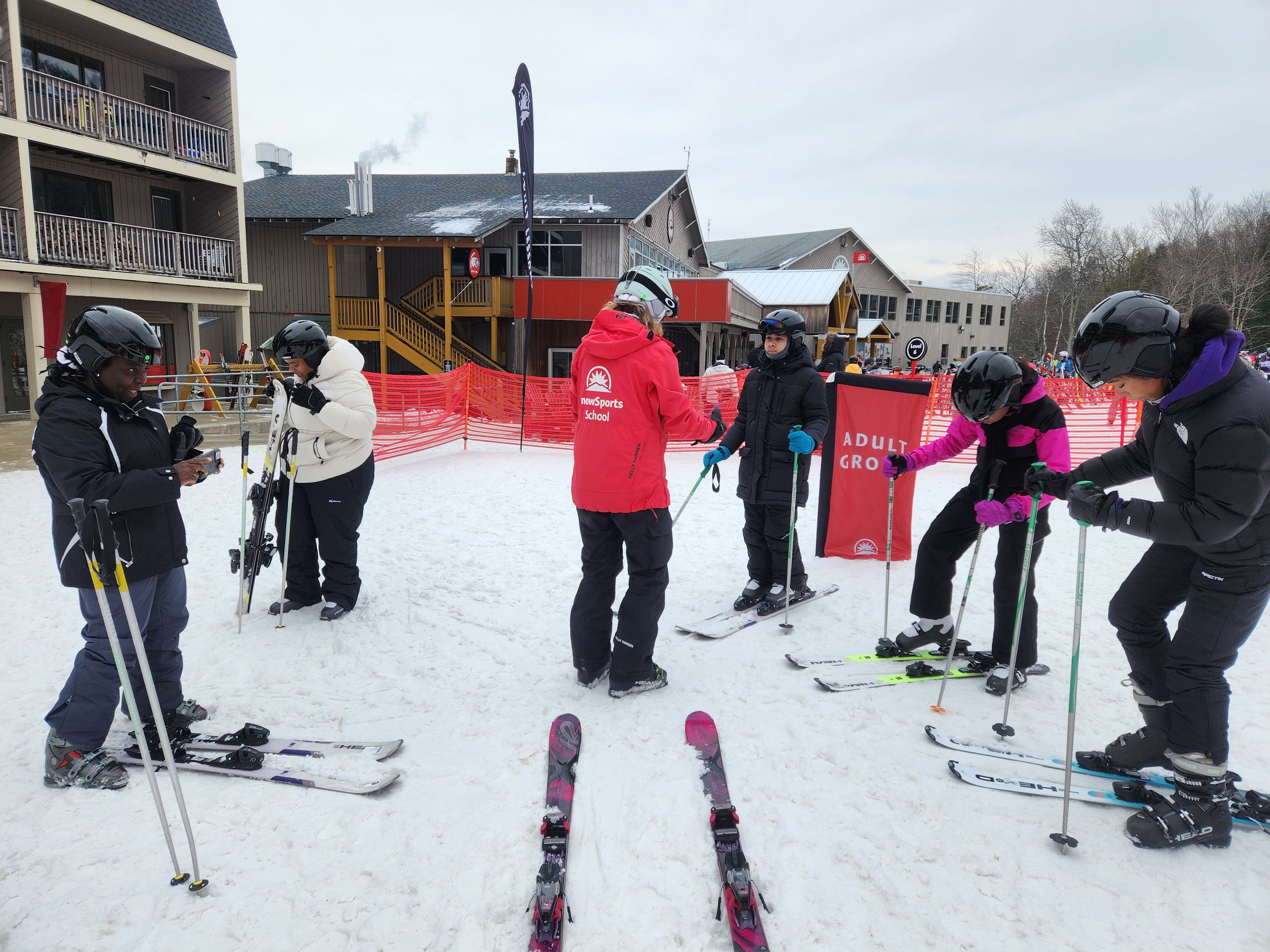 A group of skiiers are being helped by an instructor