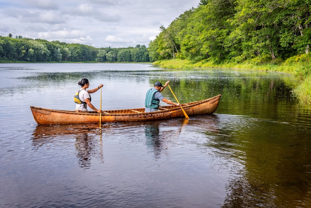 Penobscot guide Damon Galipeau and a guest paddling a birch bark canoe by Sugar Island.