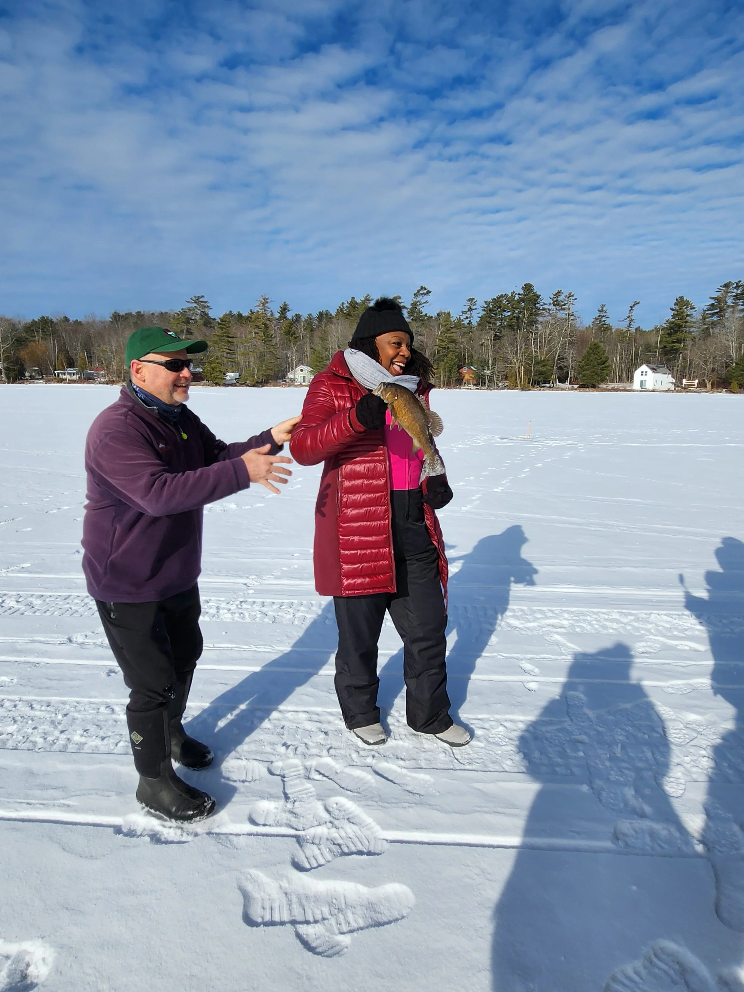 A black woman and white man stand on a frozen lake.