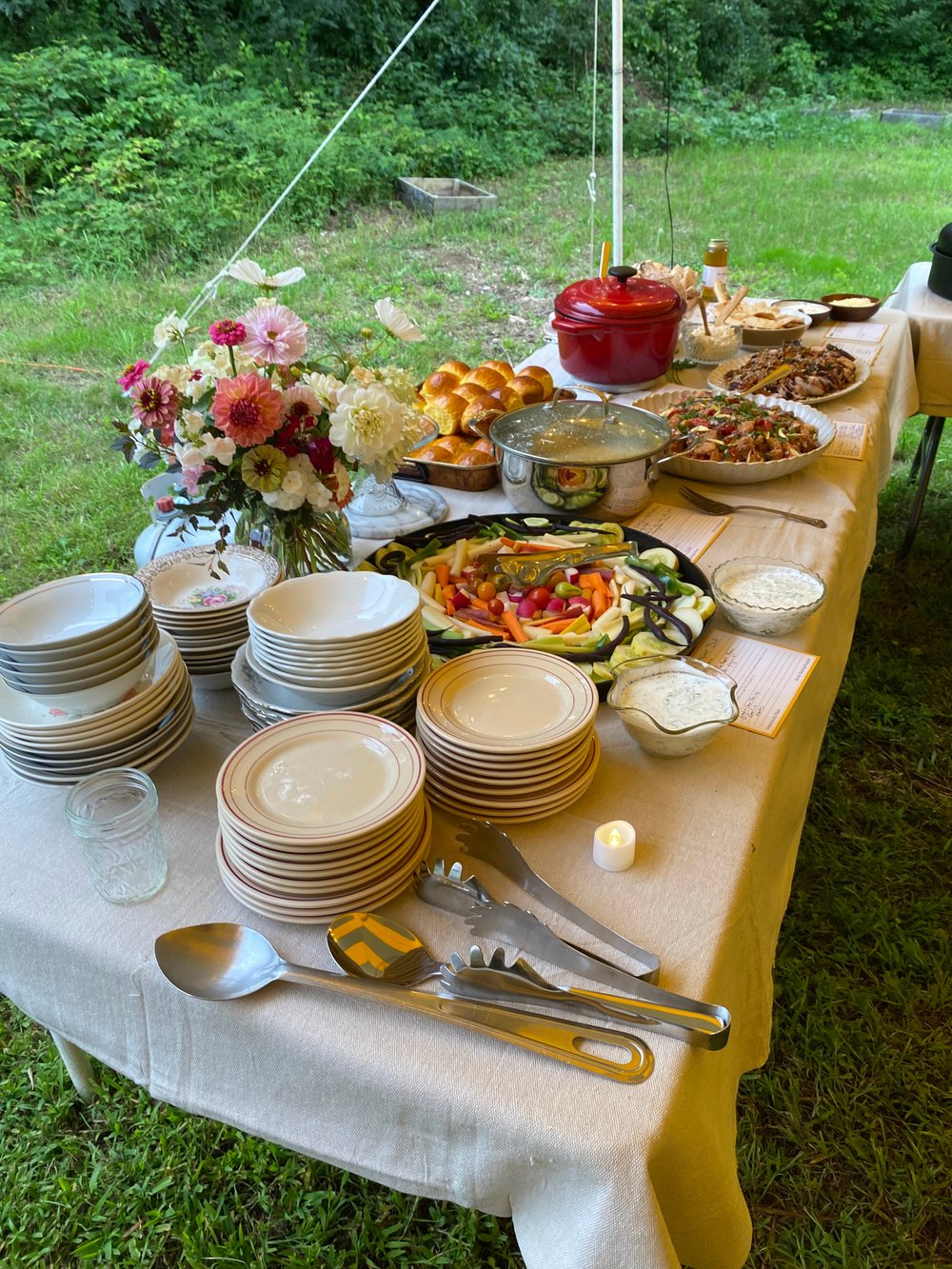 Feast- and flower-filled tables await hungry guests at Ten Apple Farm in Gray in August 2023.