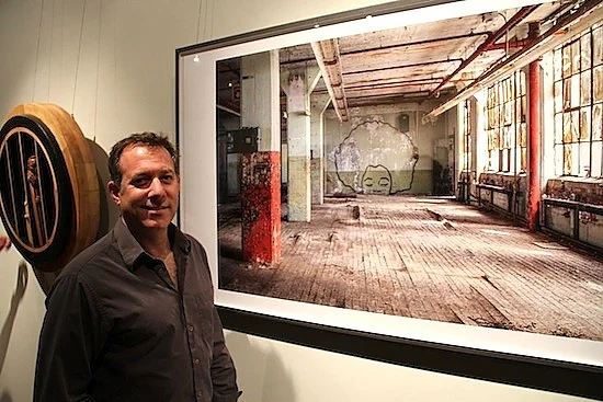 Before Makeover, Artists Preserve Winchester Legacy Among those at the well attended opening was New Haven historian Robert S. Greenberg , who is familiar with the buildings at the Winchester complex. He shared part of his comprehensive collection of New Haven artifacts and memorabilia for this report. Standing before “Castles made of Sand: Hendrix was here,” one of Bakhoum’s photos, Greenberg pointed out a particular shade of red used in areas of the vacant building. “That’s ‘Winchester Red,’” the specific color used in all the company’s brand identification Read the New Haven Independent article Before Makeover, Artists Preserve Winchester Legacy .