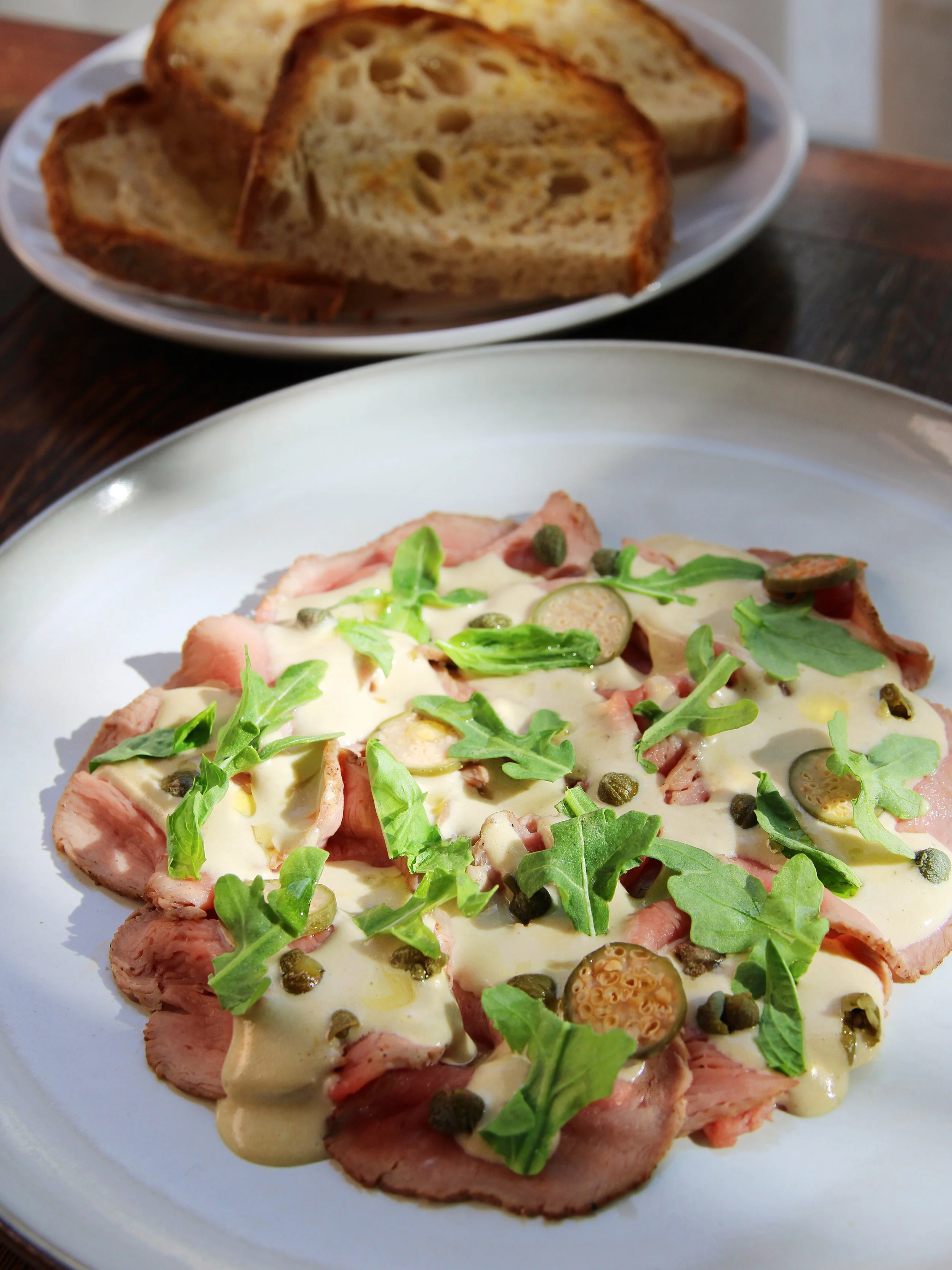 Image of Vitel Tonne dish - chilled and sliced veal, bluefin tuna dressing, capers, baby arugula, basil, sourdough toast