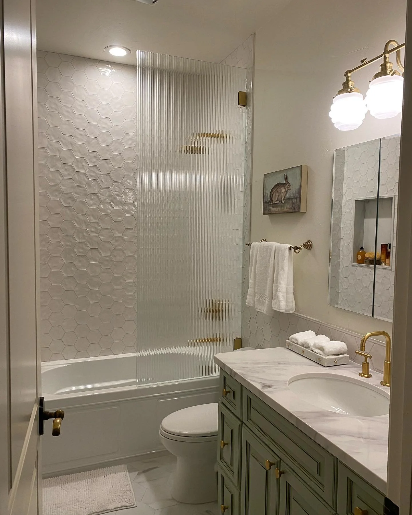 Love this hall bath remodel. ❤️ 🐝 

#bee
#hextile
#tubbathroom
#reededglass
#greenvanity
#stpetecontractor 
#womancontractor