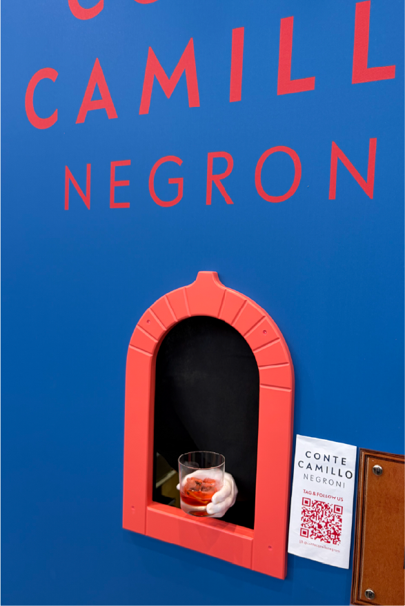  Conte Camillo Negroni booth with a red serving window handing out a classic Negroni cocktail, featuring bold blue and red branding and a QR code for engagement. 