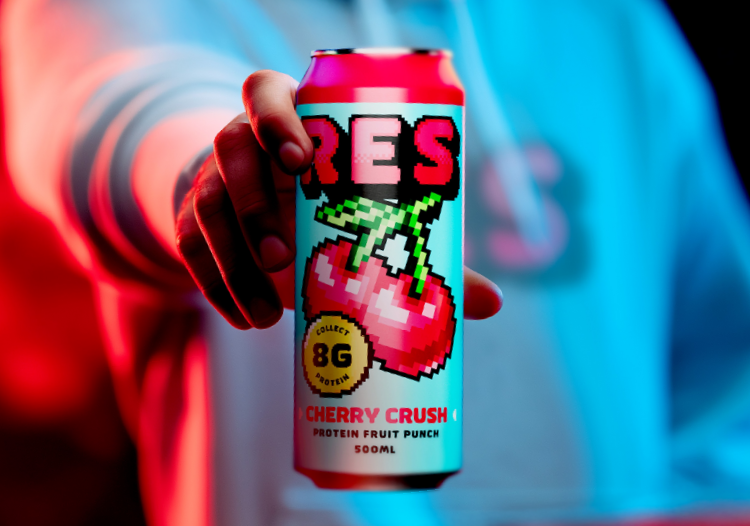  Close-up of a hand holding a colorful RES Cherry Crush protein fruit punch can with bold pixel art cherries, set against vibrant blue and pink lighting. 