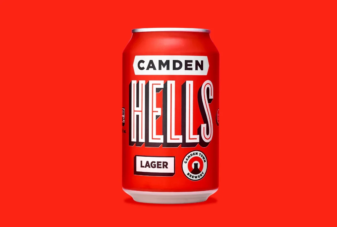  Close-up of a Camden Hells Lager can with bold red design, white and black lettering, and Camden Town Brewery logo on a solid red background. 