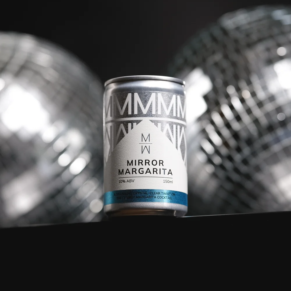  Mirror Margarita canned cocktail displayed in front of mirrored disco balls, showcasing premium RTD packaging and contemporary drinks branding in a stylish nightlife-inspired setting. 
