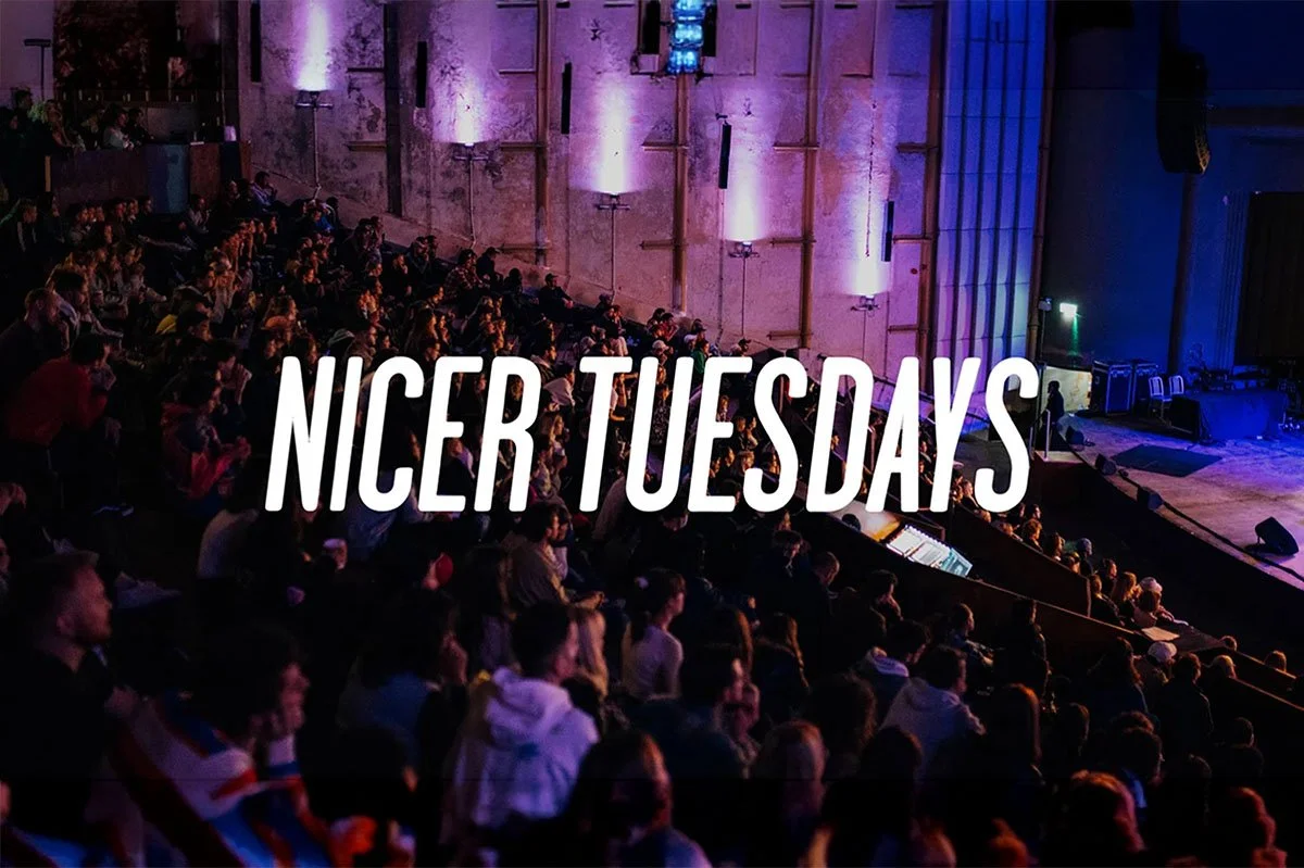 Audience seated in EartH Hackney auditorium during Nicer Tuesdays, facing a live stage presentation under purple ambient lighting, capturing a vibrant creative industry event atmosphere.