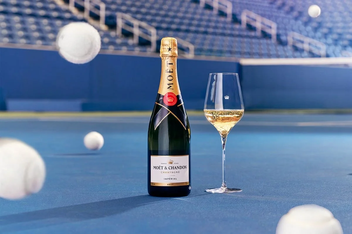 Moët & Chandon Impérial Champagne bottle and chilled glass displayed on a tennis court at the US Open, combining luxury drinks branding, live sport and premium celebration occasions.